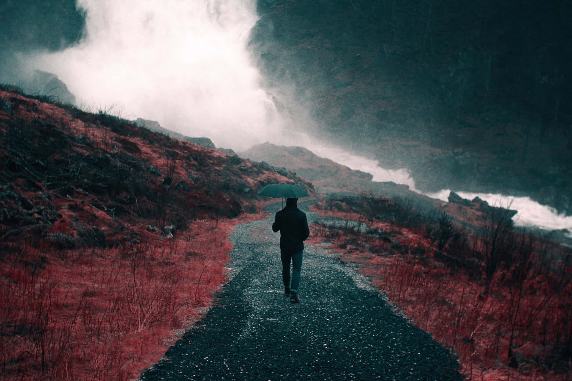 在黑暗景觀中，霧氣瀰漫的紅色小路上撐傘行走的人