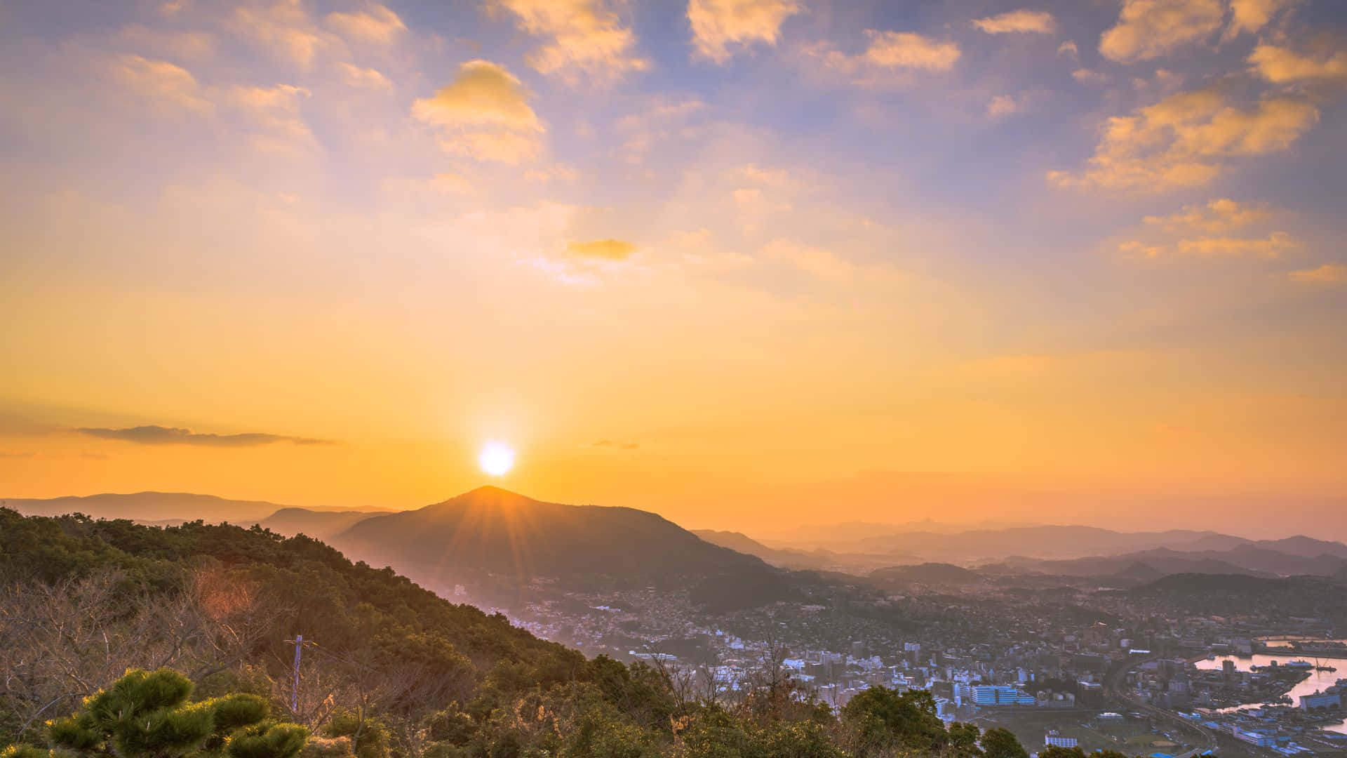 山上的夕陽，下方有小鎮