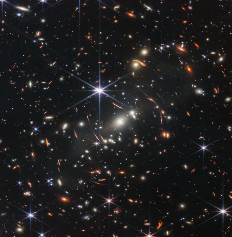 色彩繚繞的螺旋星系 壁紙 — 一個充滿無數星系和明亮恆星的宇宙景觀，背景是深邃的黑色虛空。
