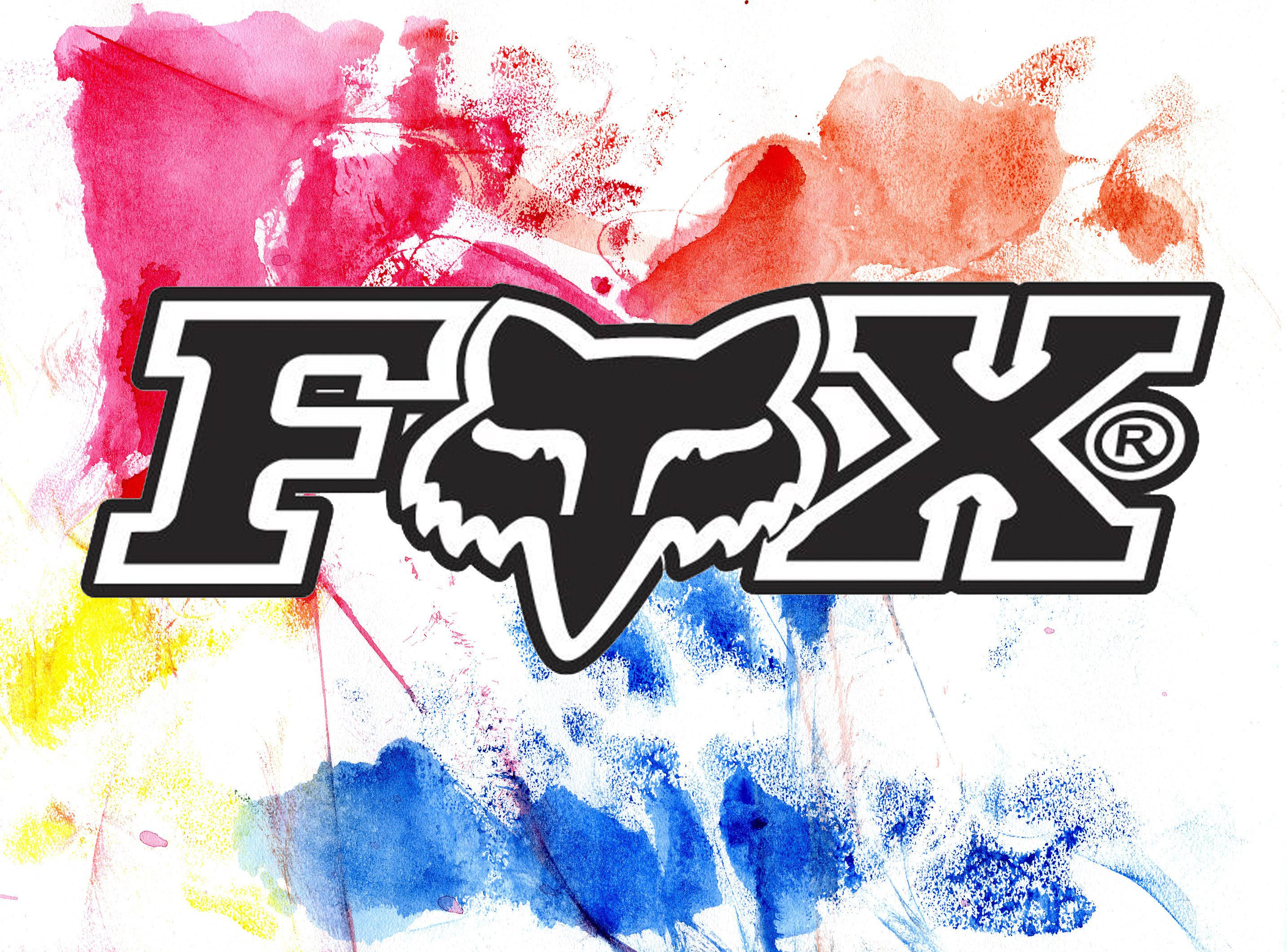色彩繽紛的 Fox Racing 沙灘摩托車標誌 壁紙 — 大膽的黑色Fox Racing標誌，中央有風格化的狐狸頭，背景是充滿活力的粉紅、紅、黃和藍色抽象水彩潑濺。