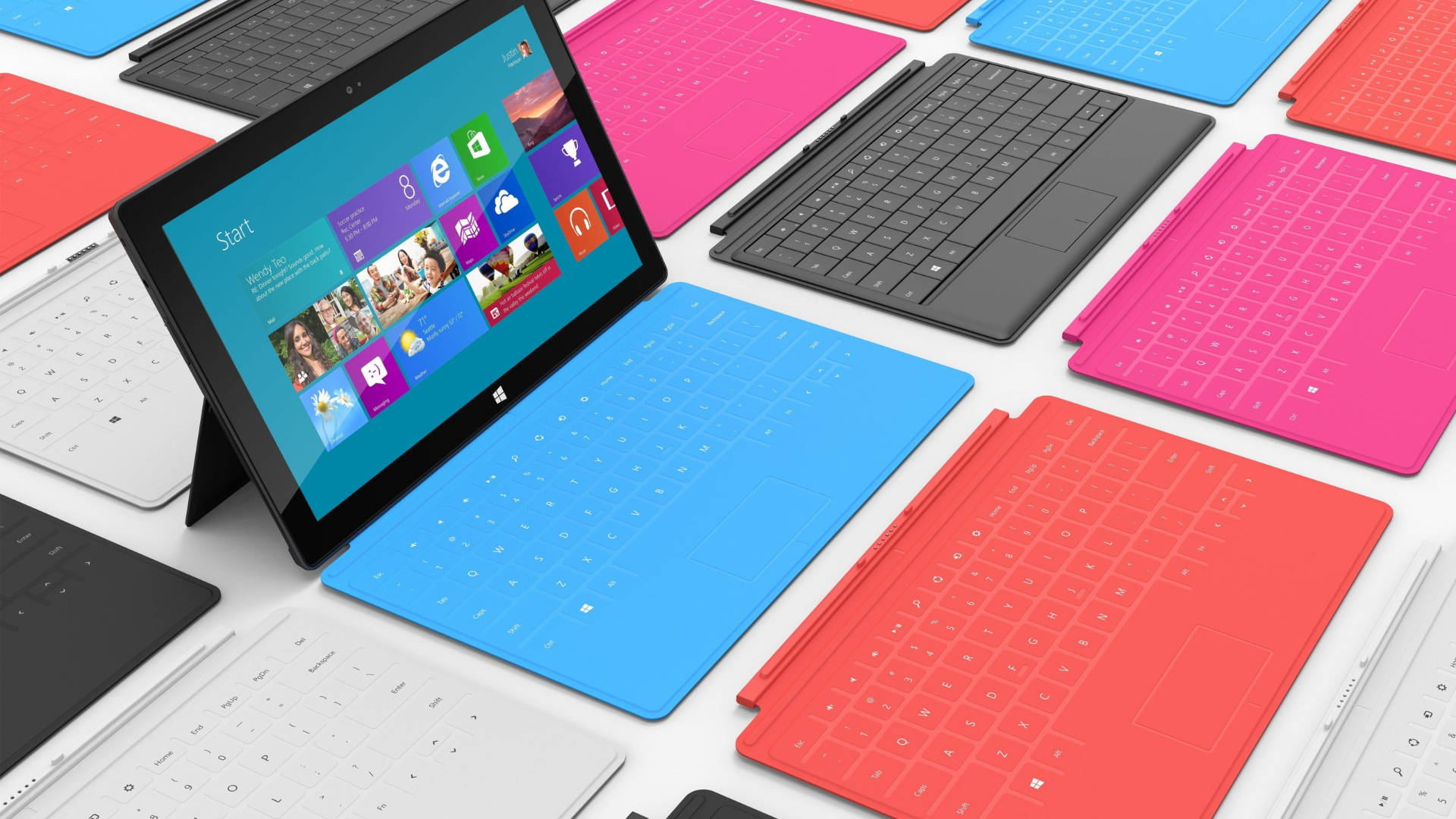 平板電腦 桌布 壁紙 — 色彩繽紛的Microsoft Surface平板電腦配備可拆卸鍵盤，整齊排列在白色表面上。