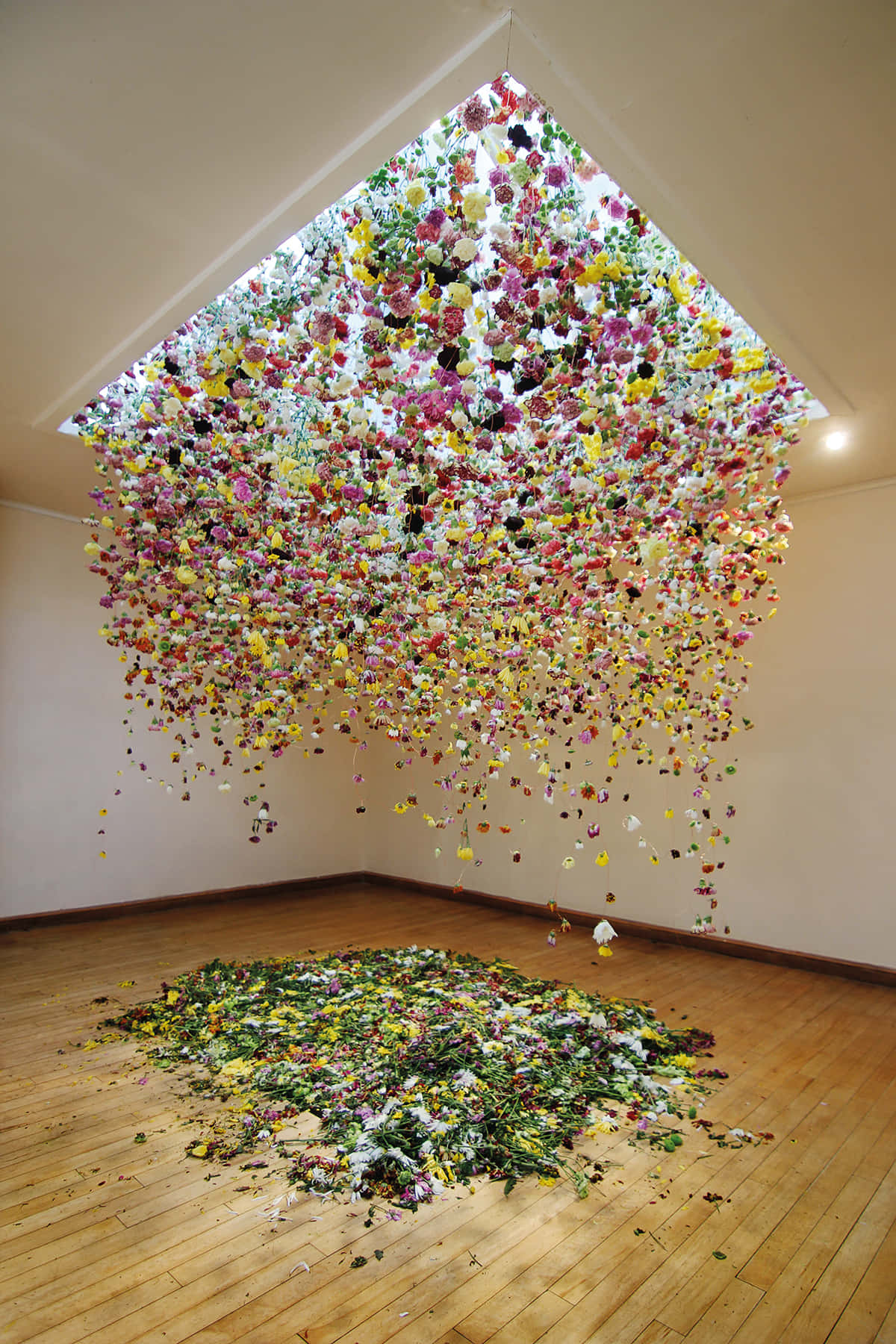 Installation Art 桌布 壁紙 — 色彩繽紛的人造花從天窗傾瀉而下，如瀑布般灑落在畫廊空間的木地板上。