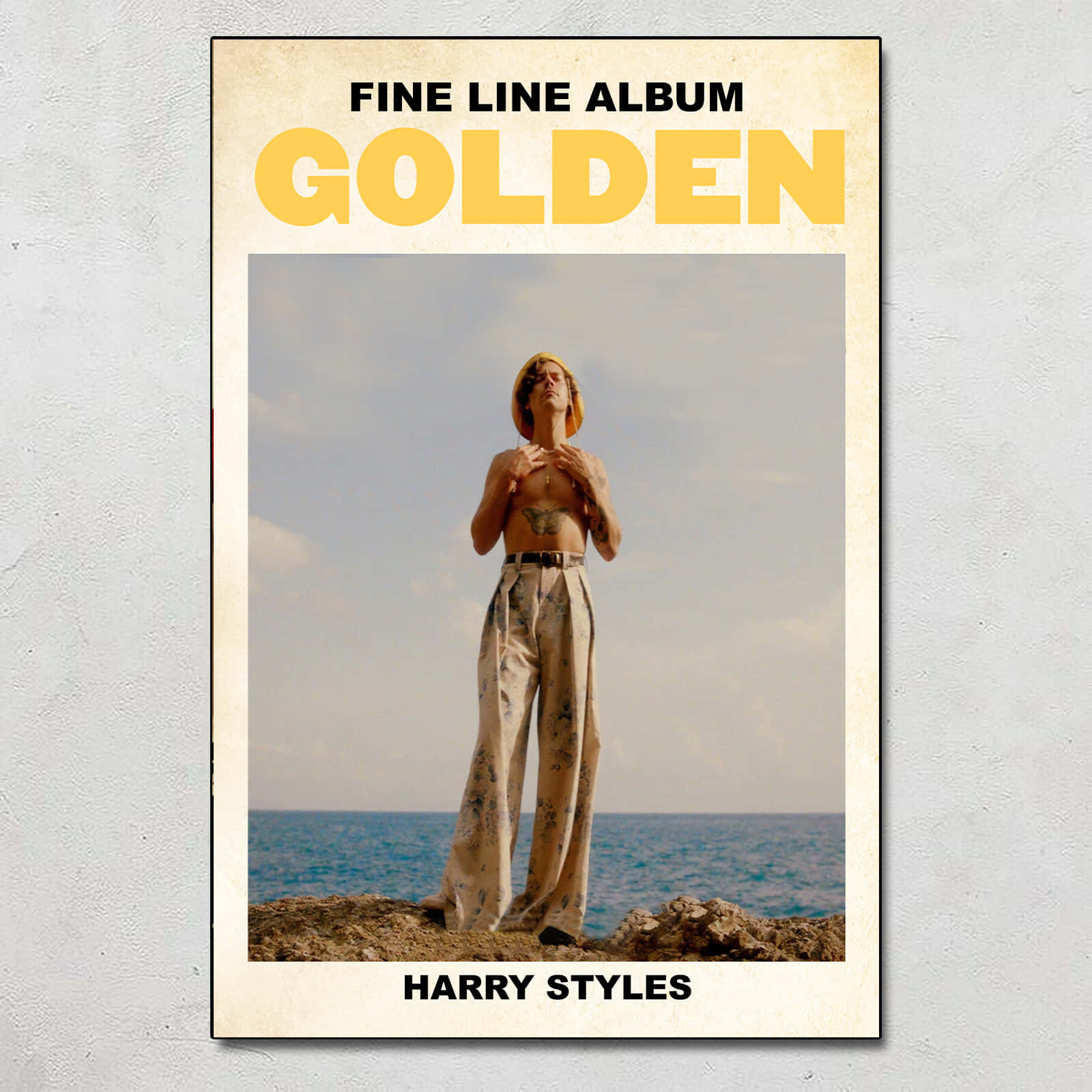 Harry Styles 赤裸上身站在懸崖上俯瞰海洋，帶有 'Golden' 專輯文字。