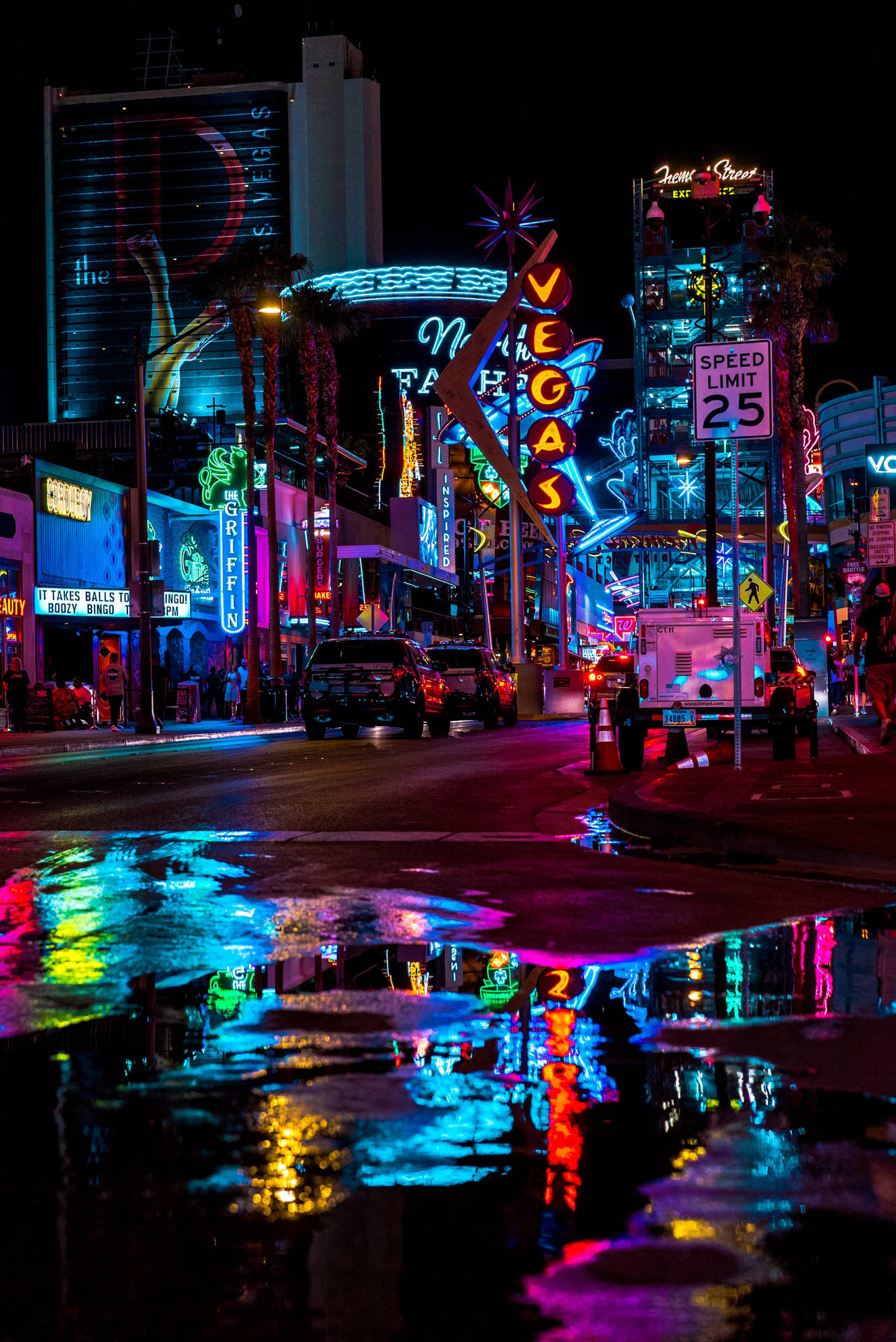 拉斯維加斯雨夜街道，霓虹招牌倒映在水坑中。