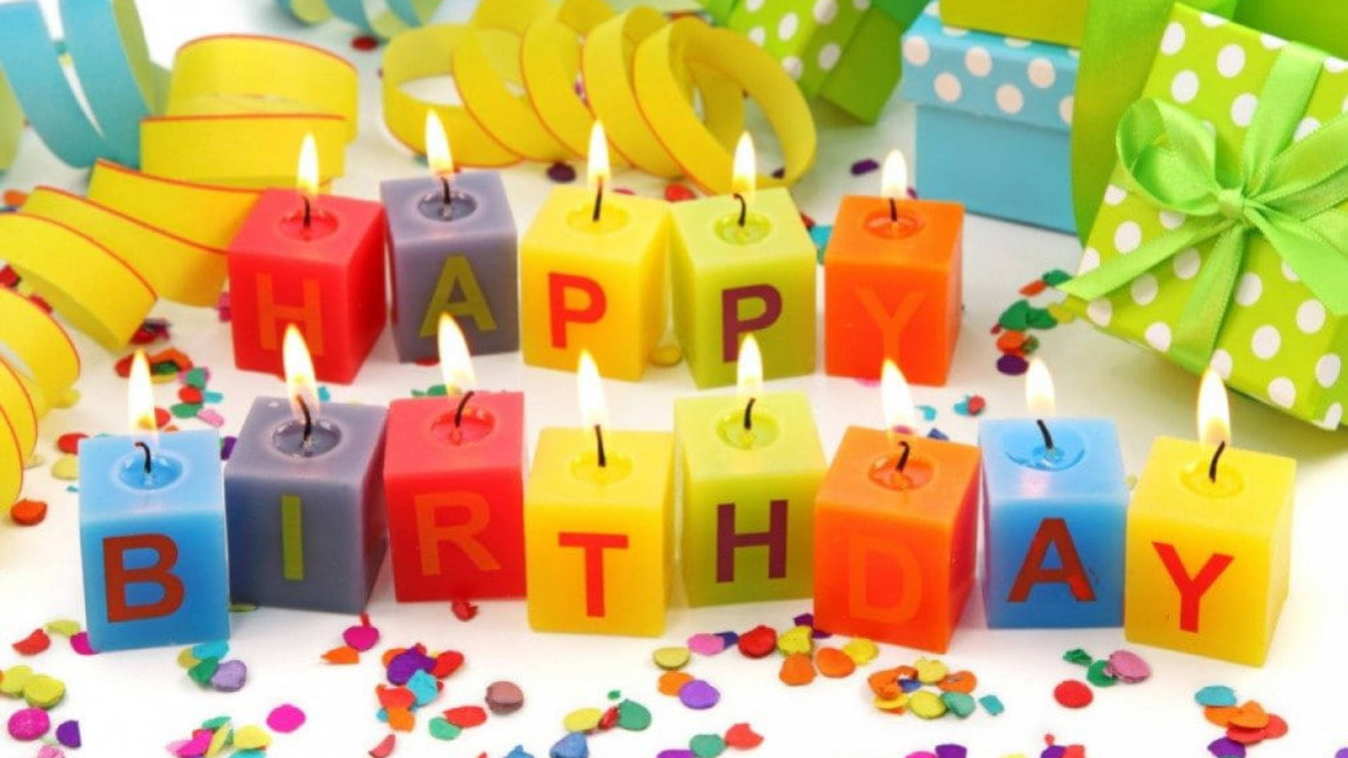 my 桌布 壁紙 — 色彩繽紛的塊狀蠟燭拼出「HAPPY BIRTHDAY」，點燃的火焰周圍散落著五彩紙屑和禮物盒。