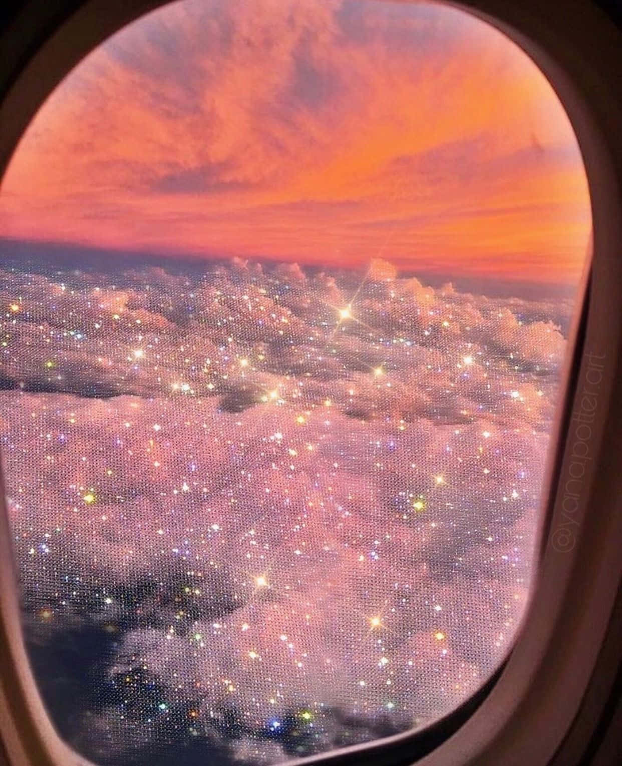 從飛機窗戶看到的景色，顯示閃爍的雲朵和橙色日落天空。