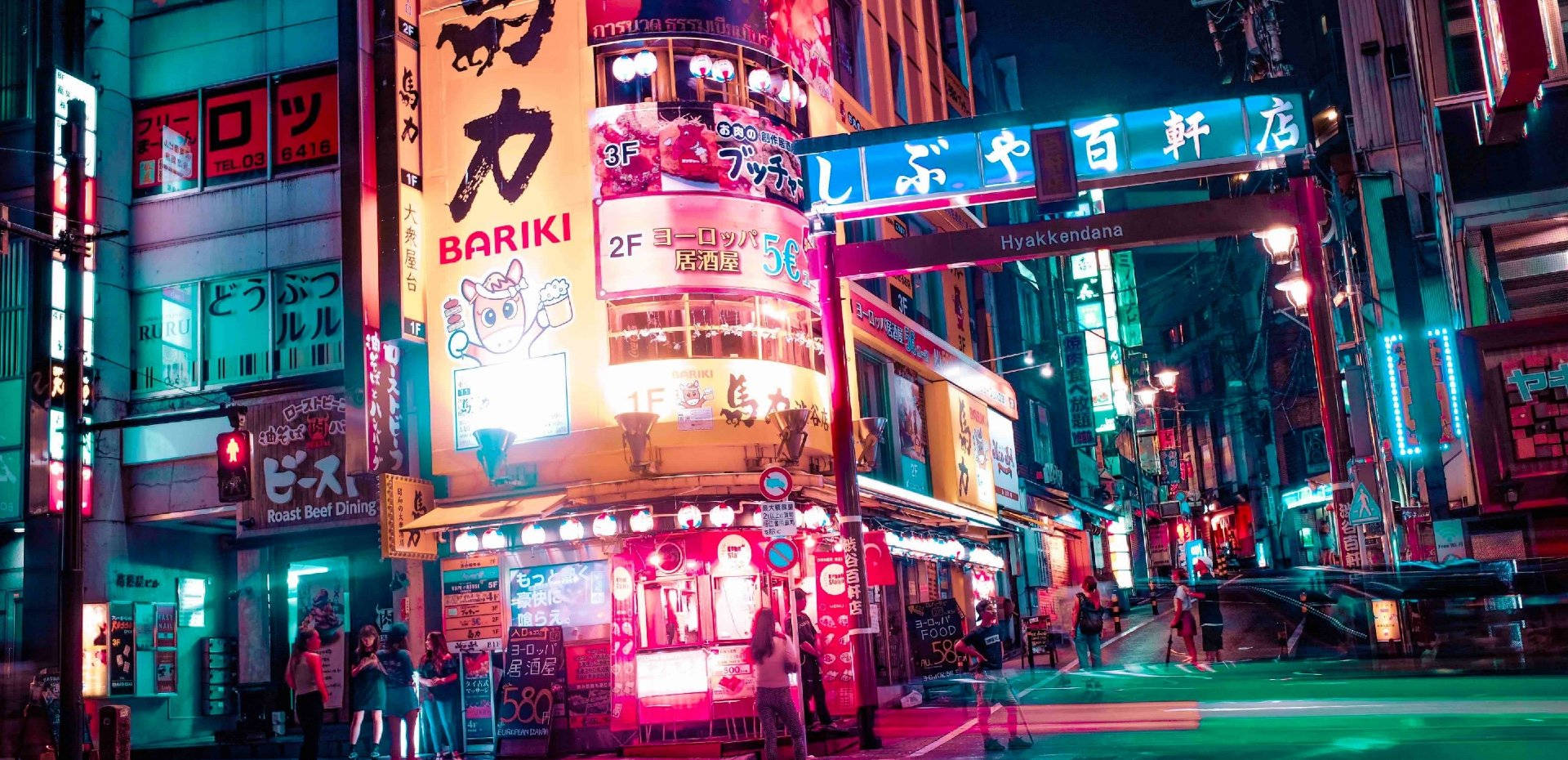 夜晚霓虹燈照亮東京街道，有發光的招牌和行人。