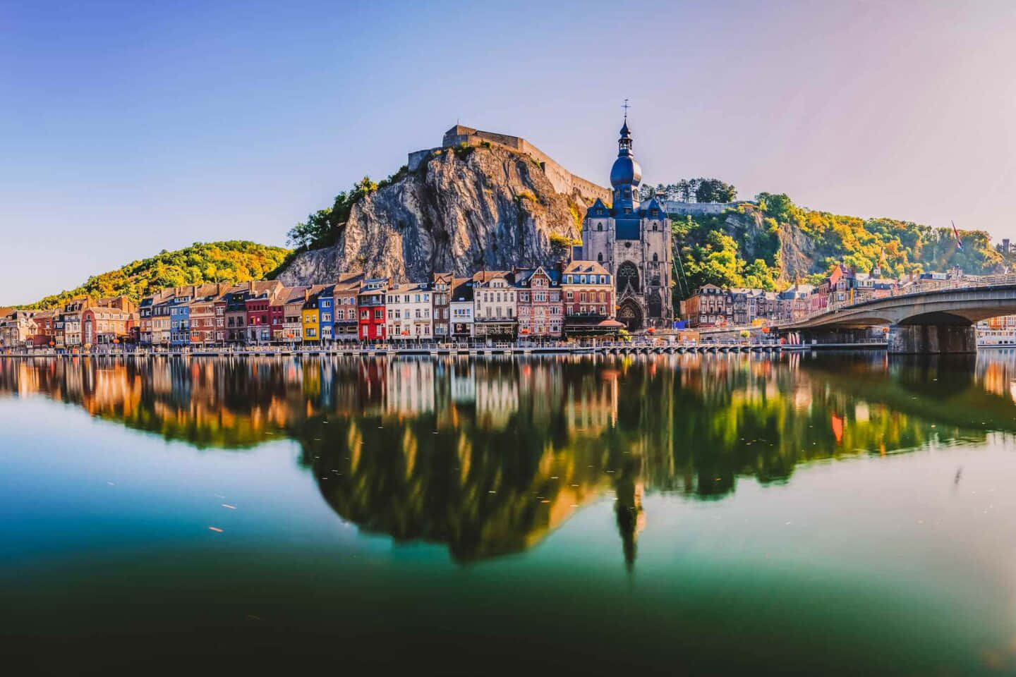 Beautiful City 桌布 壁紙 — 色彩繽紛的歷史建築物和一座大教堂在晴朗的藍天下完美地倒映在平靜的河水上。