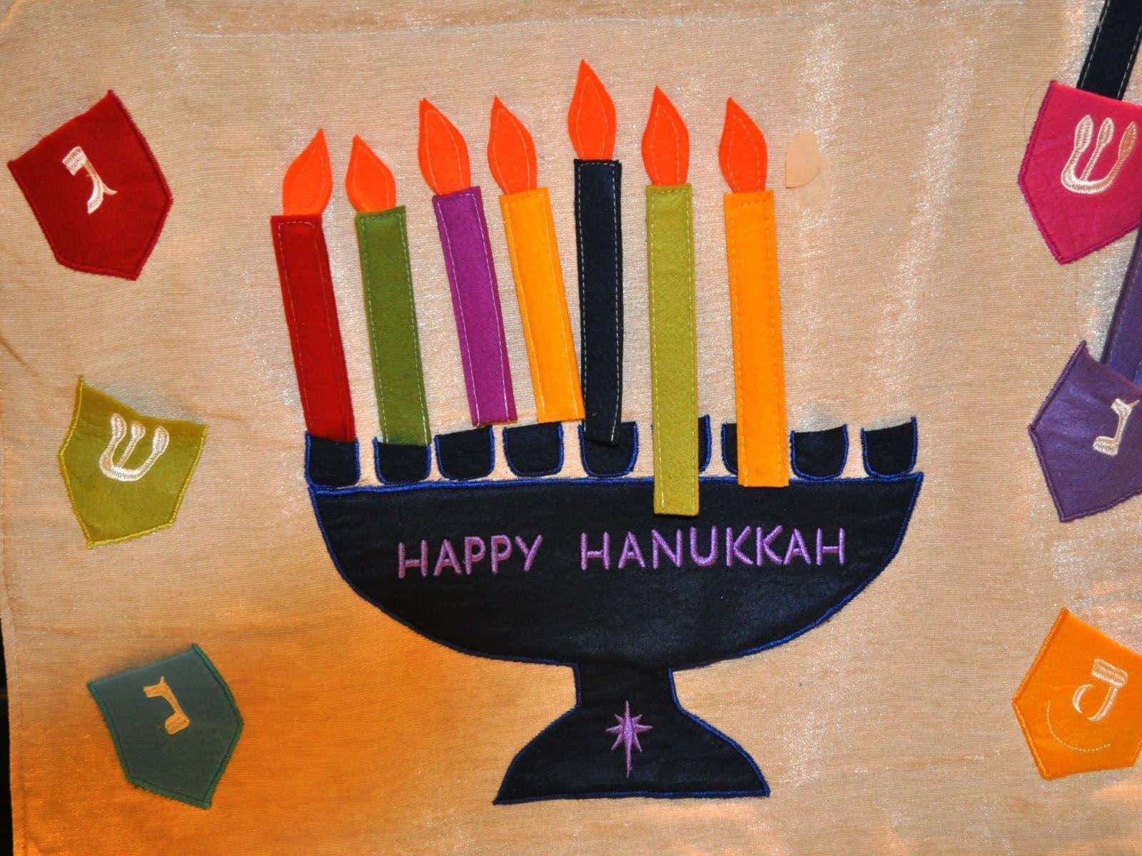 Hanukkah 桌布 壁紙 — 色彩繽紛的氈製光明節燭台，點燃的蠟燭和希伯來字母，背景為有紋理的布料。