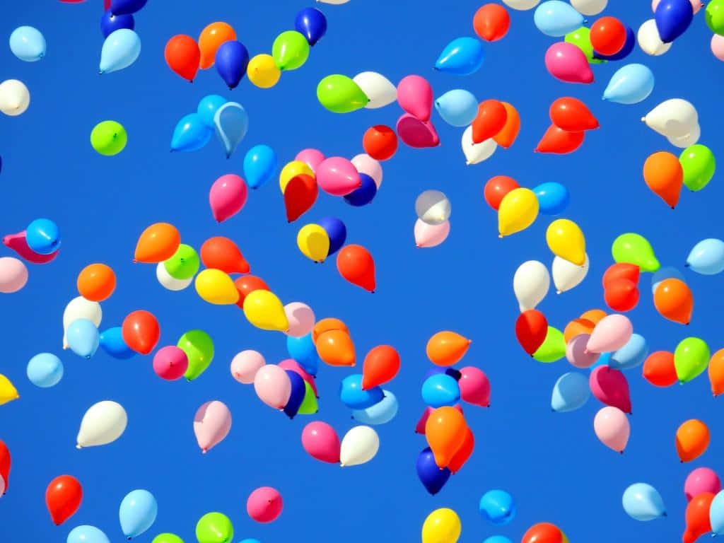 Balloon 桌布 壁紙 — 色彩繽紛的氣球在晴朗明亮的藍天上歡快地飄浮。