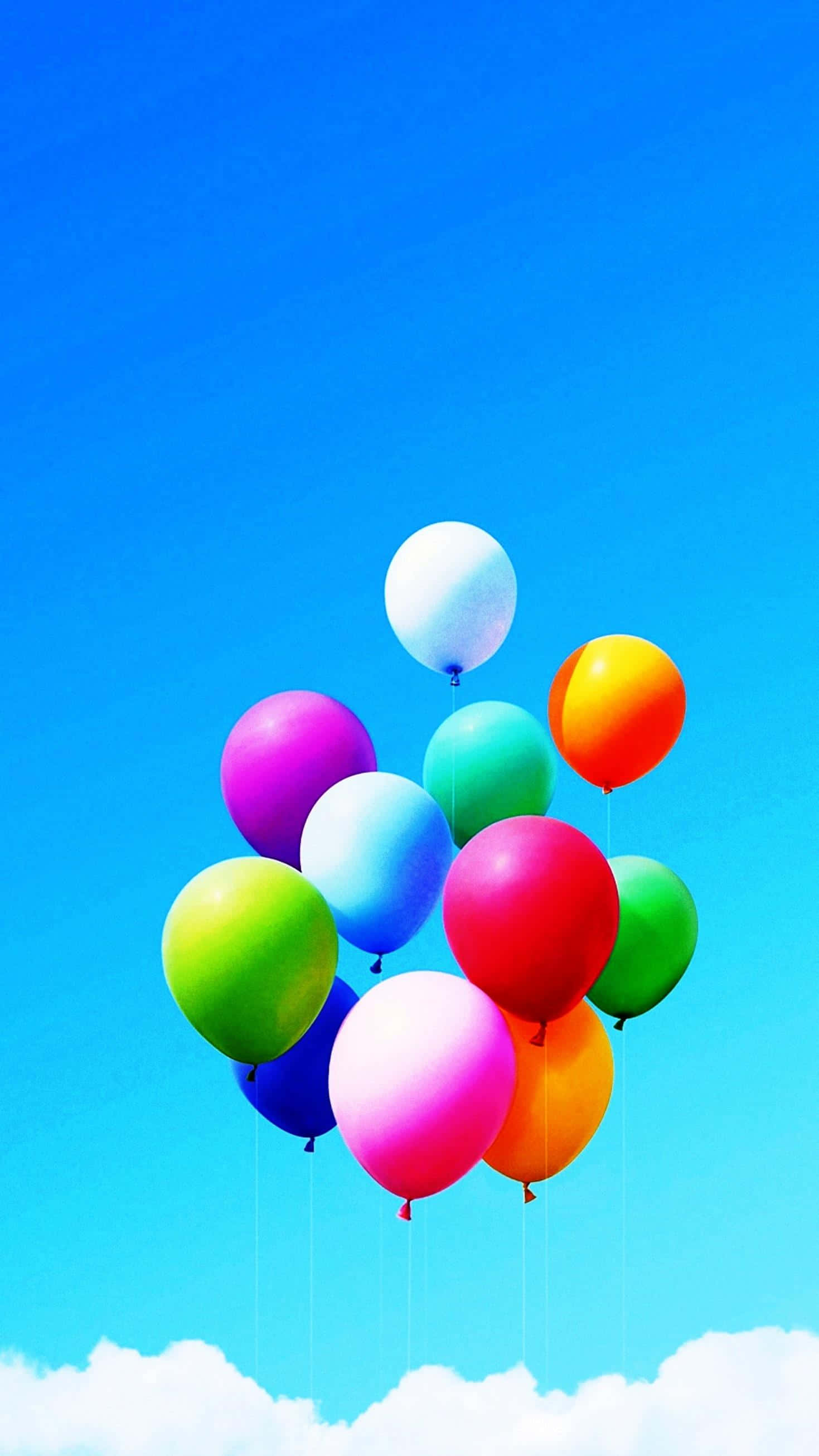Pretty Phone 桌布 壁紙 — 色彩繽紛的氣球在晴朗的藍天和白雲下歡快地飄浮。