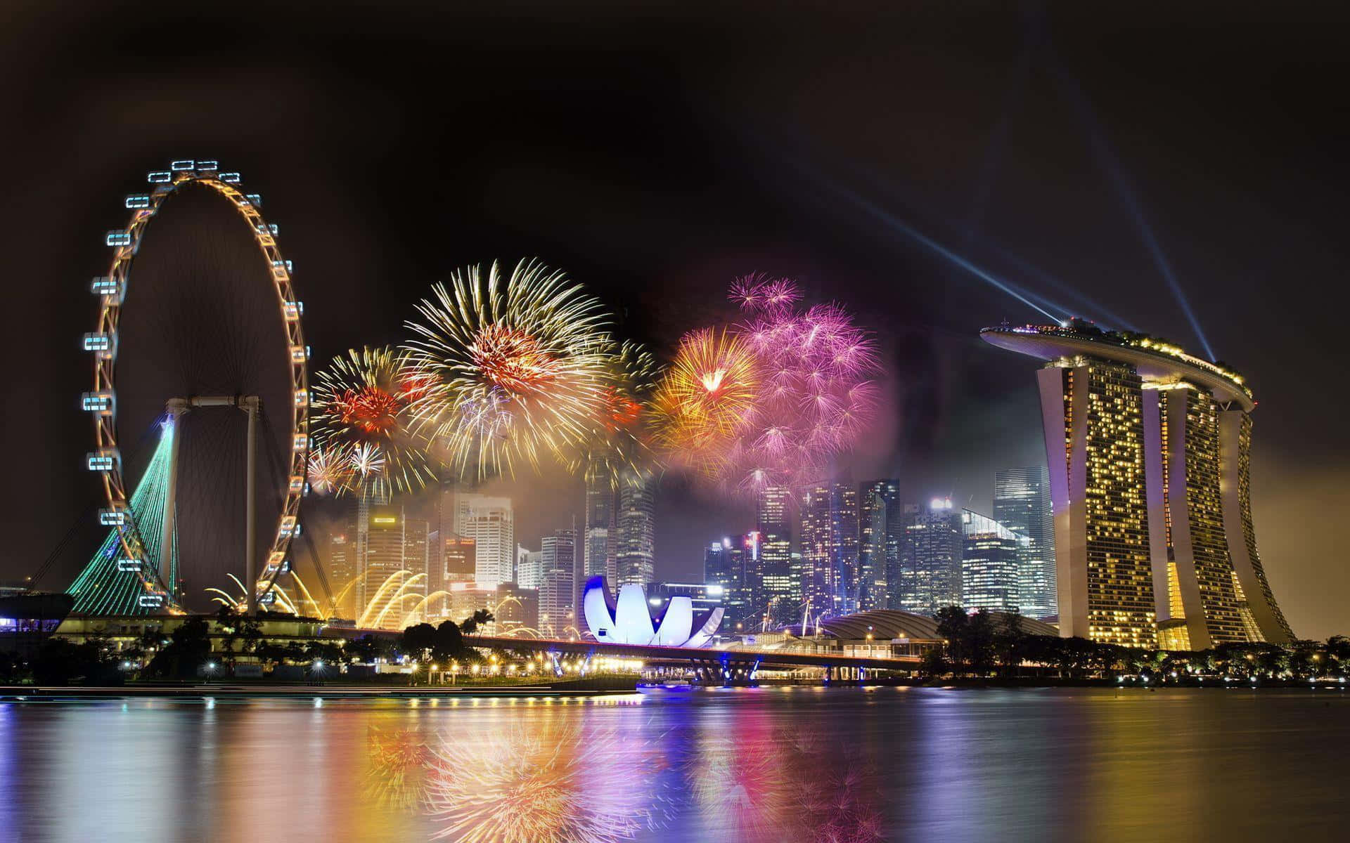 Singapore 桌布 壁紙 — 色彩繽紛的煙花在新加坡的天際線上綻放，夜晚倒映在濱海灣金沙和新加坡摩天輪附近的水面上。