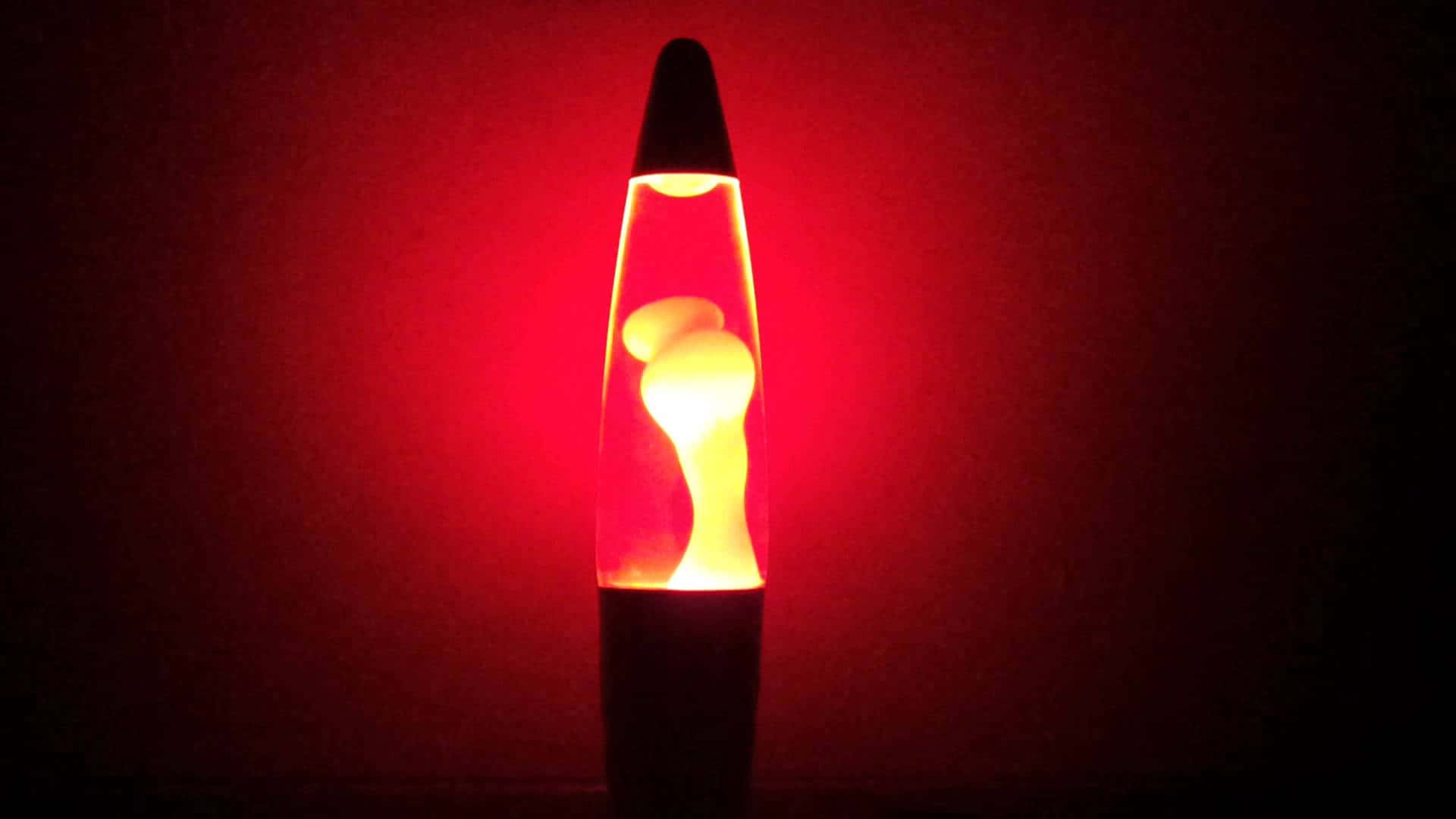 色彩繽紛的熔岩燈 壁紙 — 一盞發光的熔岩燈在昏暗的房間裡，以深紅色背景襯托著溫暖的琥珀色蠟，脈動著光芒。