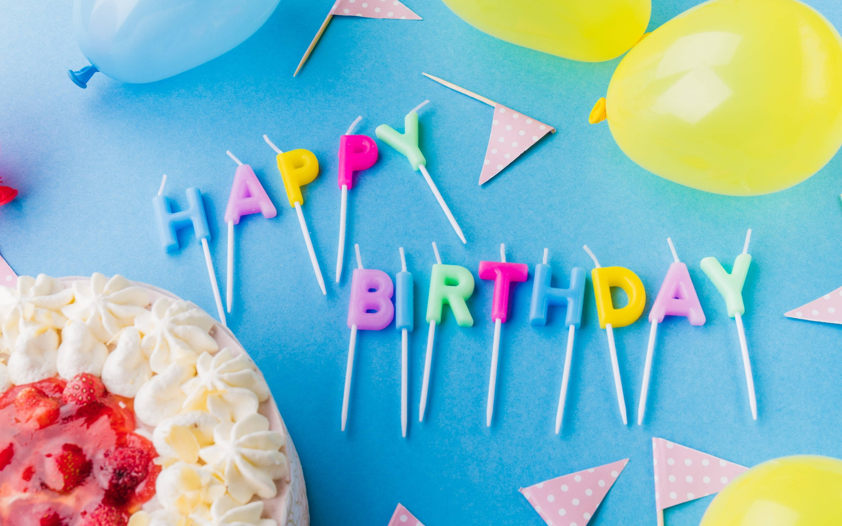 birthday blessings 桌布 壁紙 — 色彩繽紛的生日蠟燭在藍色表面上拼出happy birthday，旁邊有士多啤梨蛋糕和氣球。