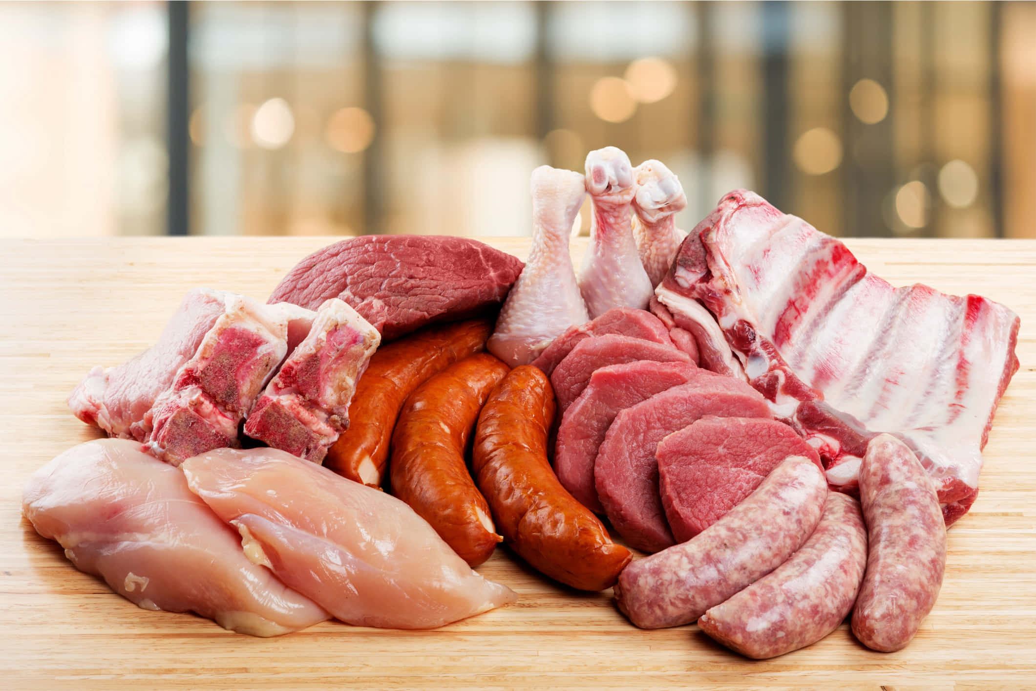 meat 桌布 壁紙 — 色彩繽紛的生肉拼盤，包括雞胸肉、肋骨、香腸和牛肉，擺放在木製砧板上。