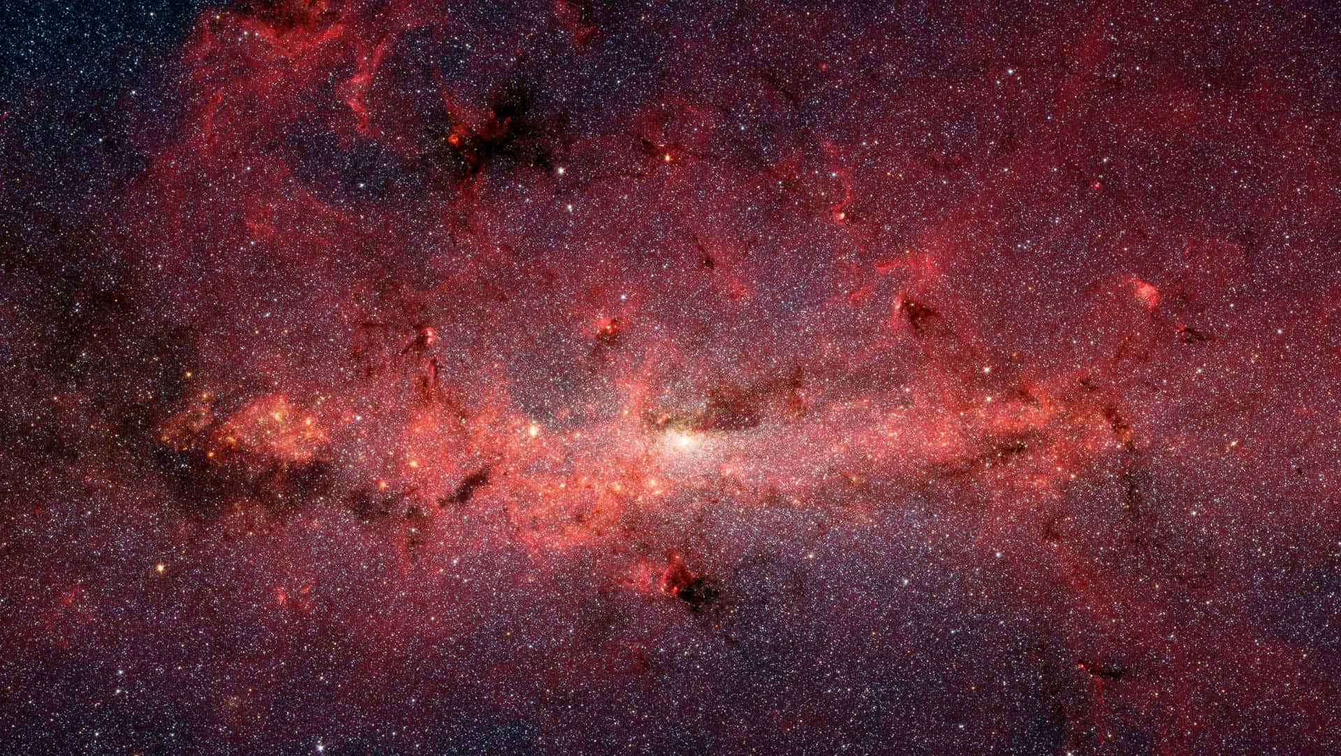 深空中一個帶有發光星星和宇宙塵埃的鮮豔紅色和橙色星雲。