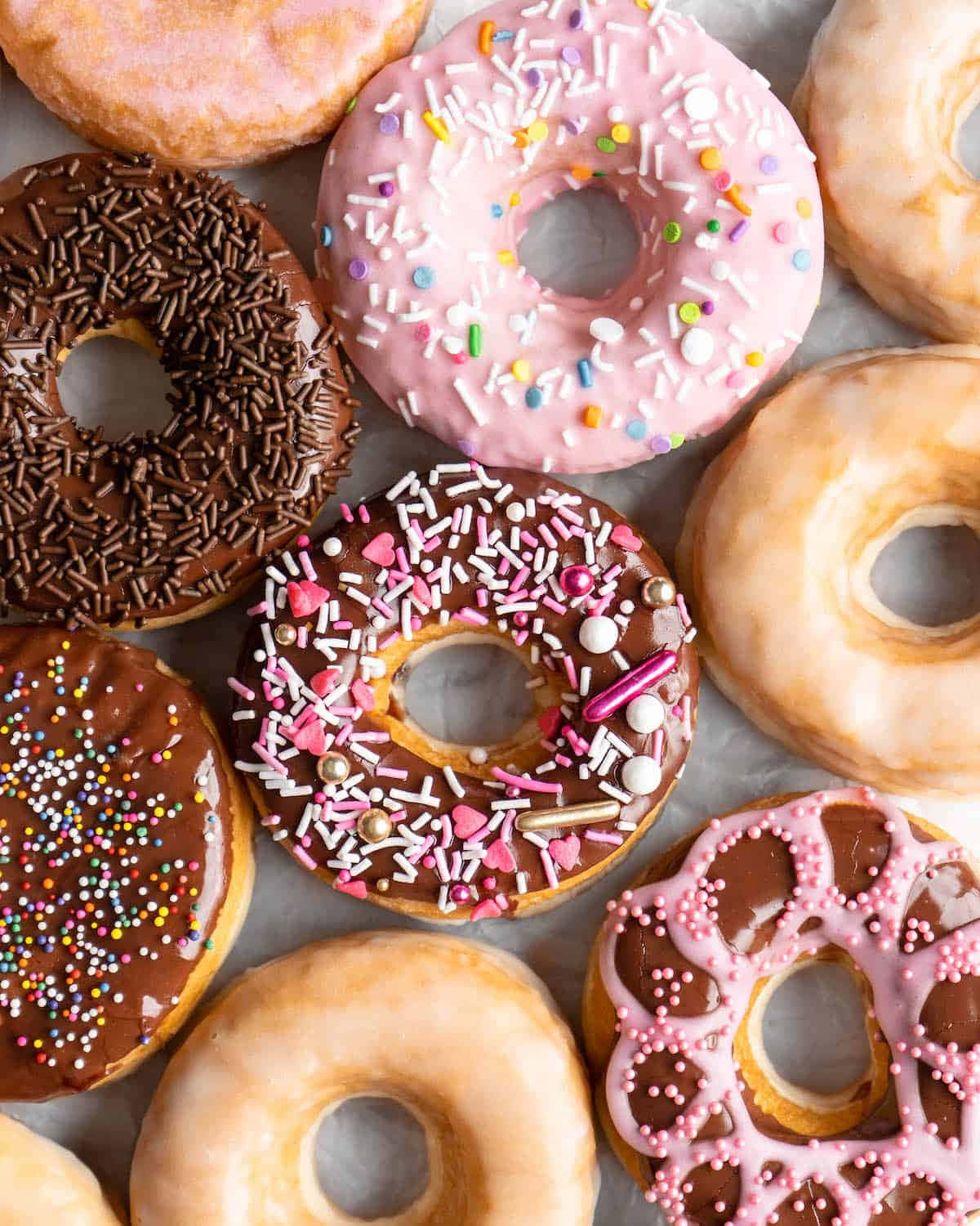 Glazed Donut 桌布 壁紙 — 色彩繽紛的釉面和灑糖甜甜圈，以誘人的俯拍鏡頭排列。