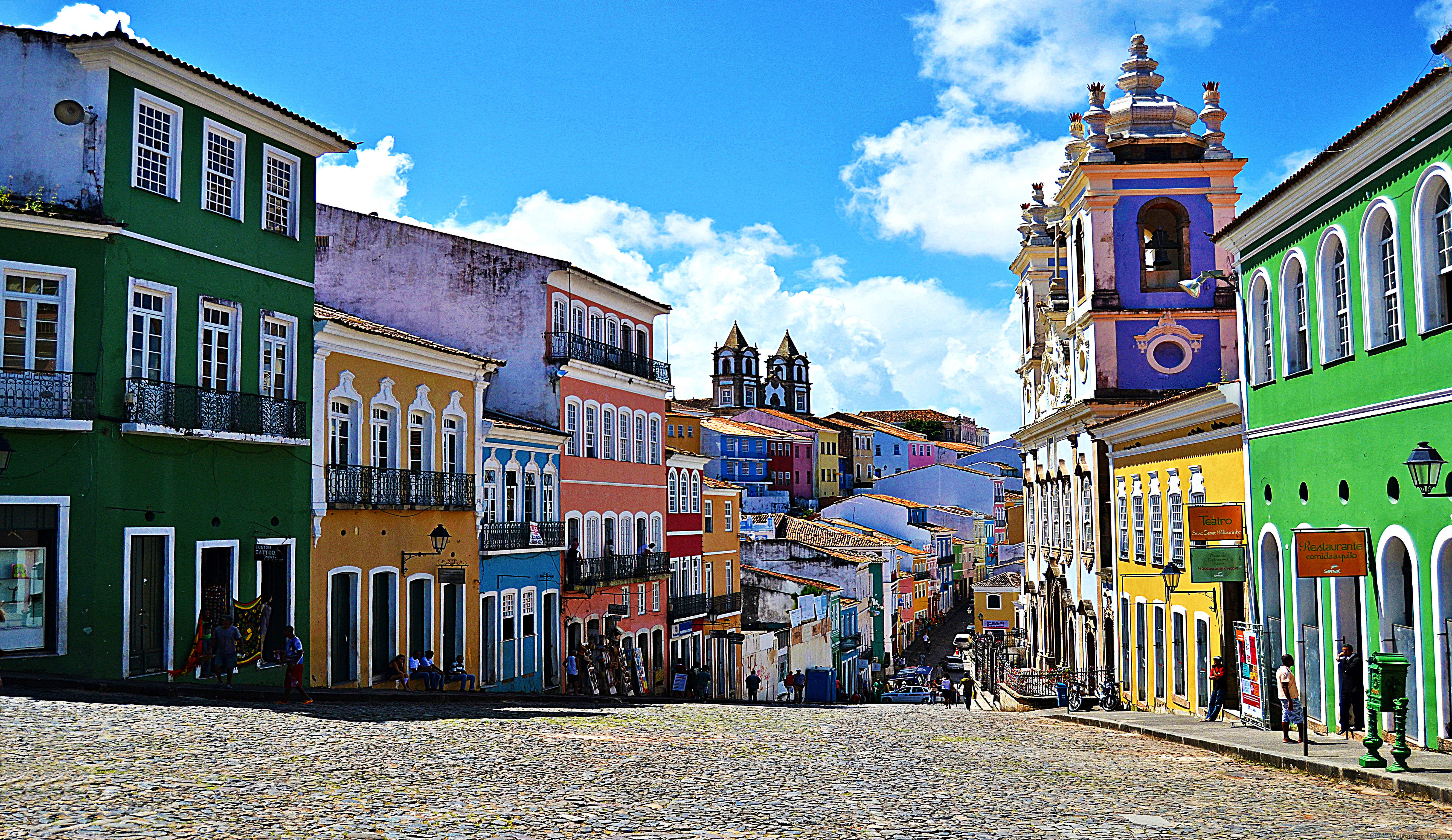 Brazil 桌布 壁紙 — 色彩鮮豔的殖民時期建築排列在鵝卵石街道上，上方是晴朗的藍天和蓬鬆的白雲。