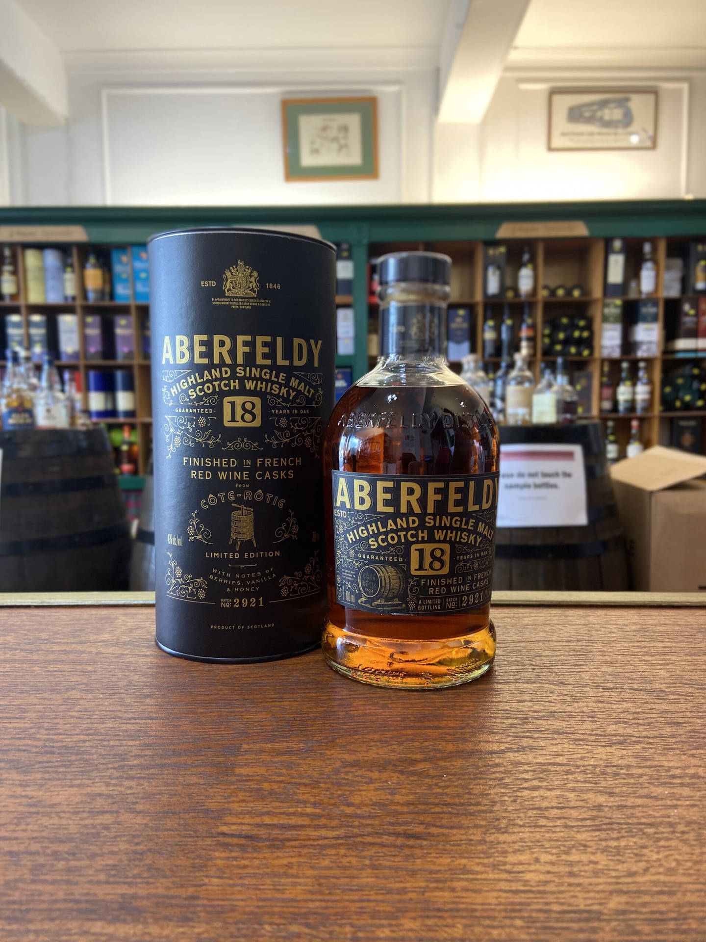 Aberfeldy 18年威士忌酒瓶和禮盒放在威士忌店的木質櫃檯上。