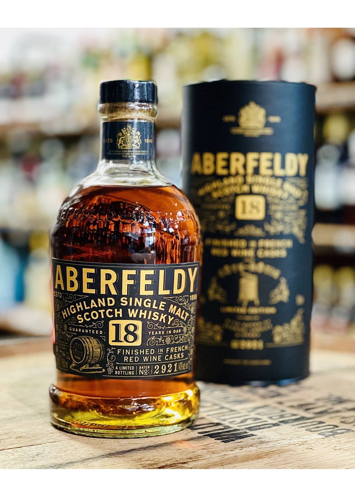 Aberfeldy 18年威士忌酒瓶和盒子放在店內木質櫃檯上。