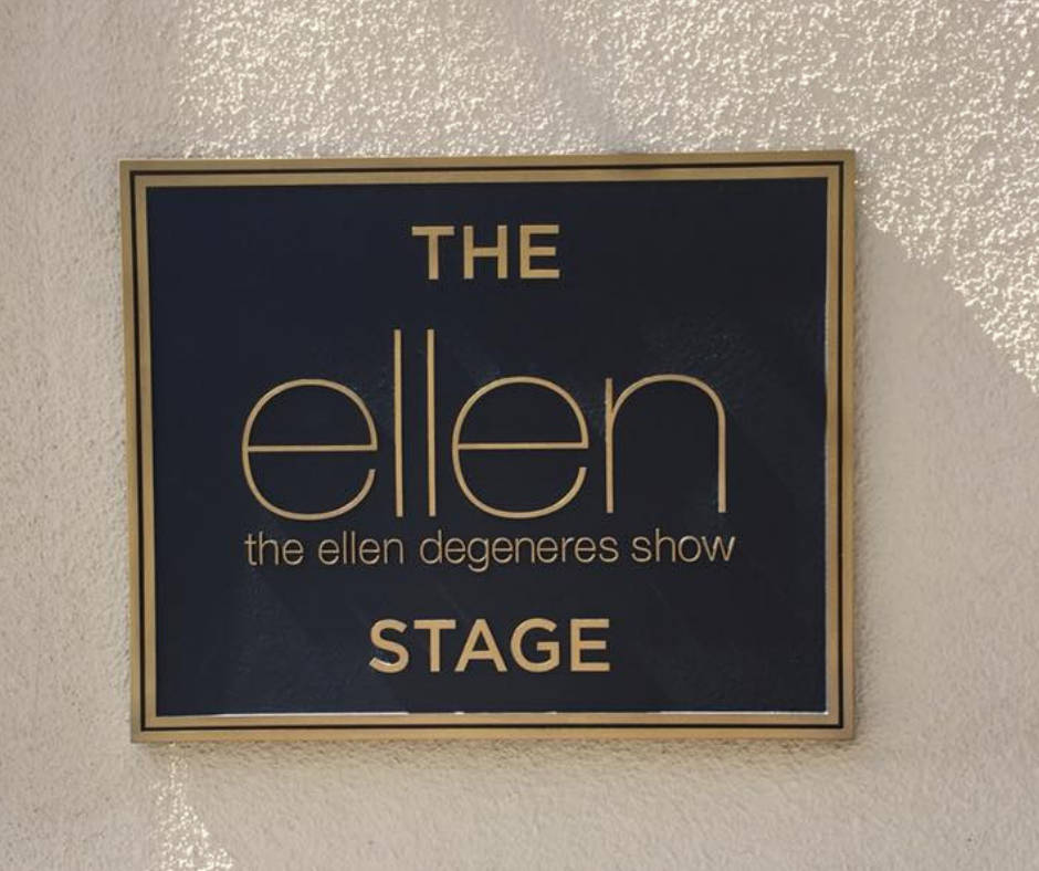 安裝在有紋理牆上、陽光照射下的The Ellen DeGeneres Show Stage標誌。