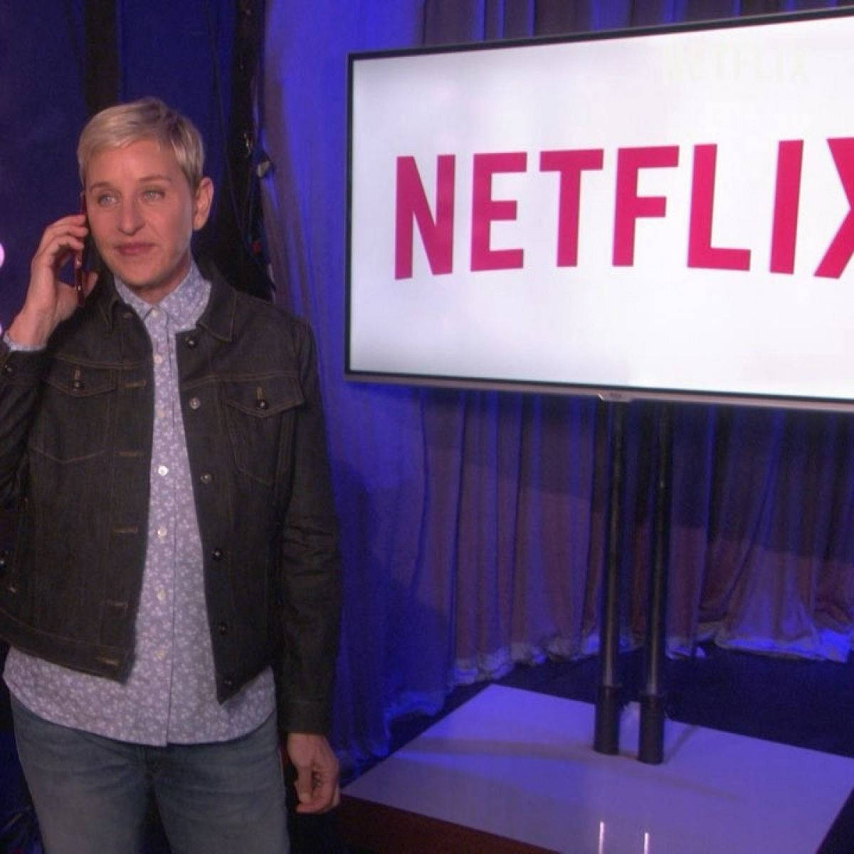 艾倫·狄珍妮在舞台上拿著電話，靠近Netflix標誌屏幕。