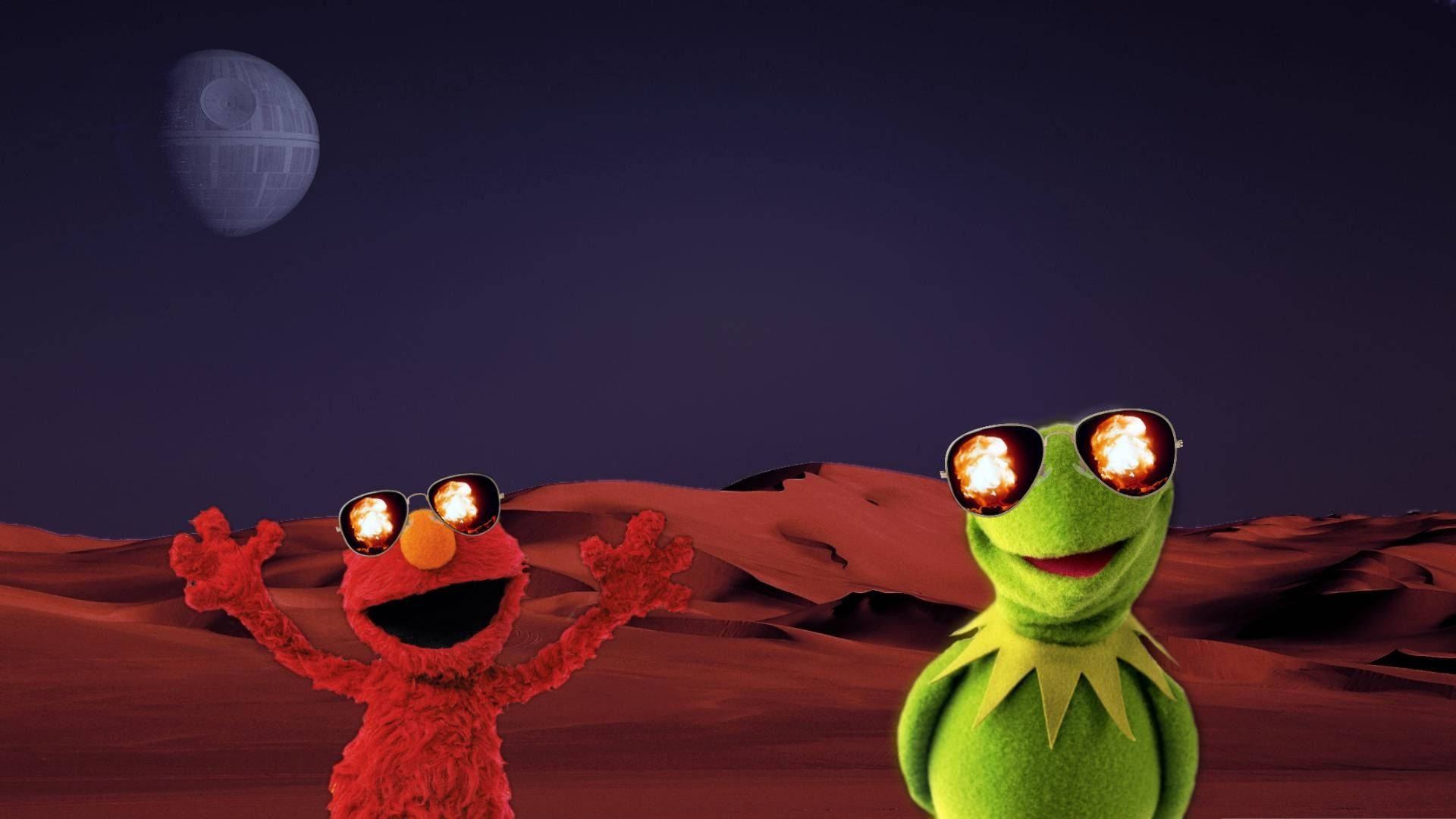 Elmo 和青蛙 Kermit 戴著帶火焰鏡片的太陽眼鏡，站在紅色沙漠上，天空中有死星。