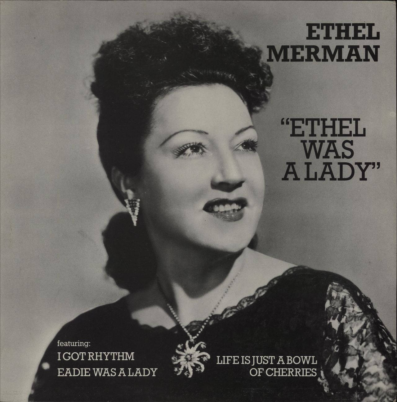 艾瑟爾·默曼歌曲封面肖像 壁紙 — Ethel Merman 自信微笑的復古黑白肖像，身穿蕾絲邊連衣裙，帶有粗體文字疊加。
