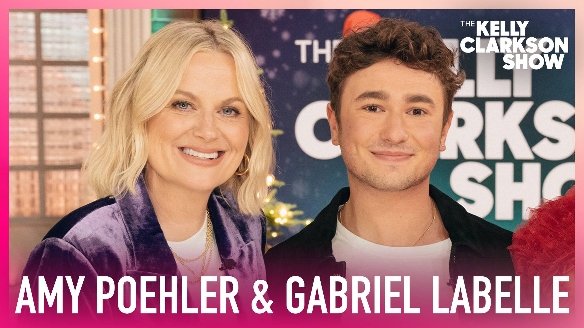 Amy Poehler 和 Gabriel Léveille 在 The Kelly Clarkson Show 場景中微笑，伴有節日燈光。