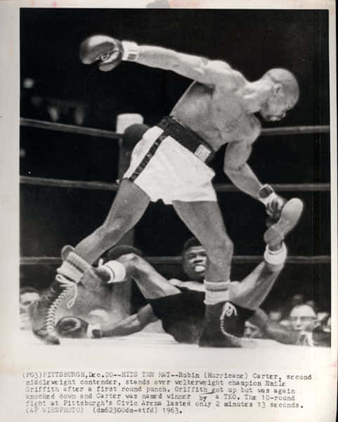 拳擊手 Rubin Carter 站在拳擊台上倒下的對手 Ray Griffith 上方。