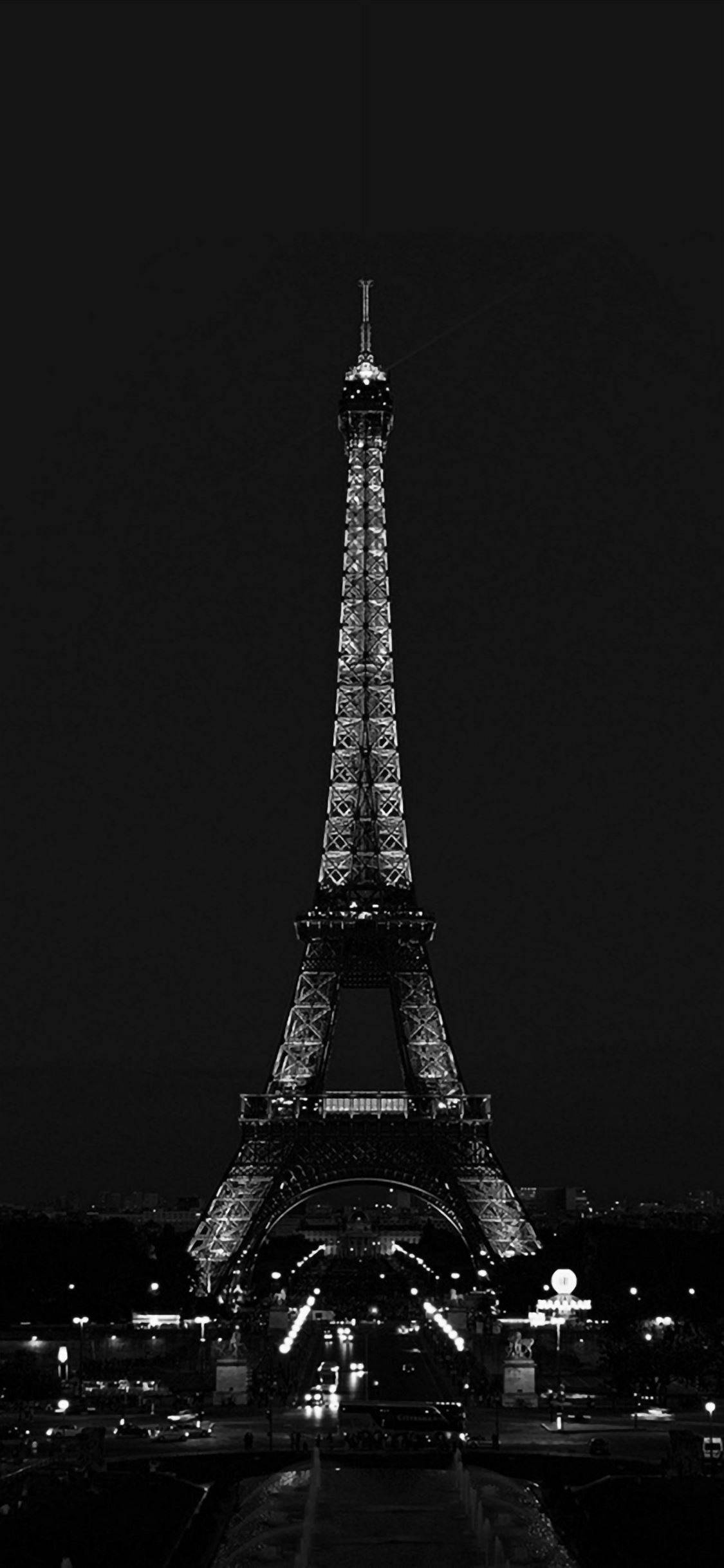 Eiffel Tower 桌布 壁紙 — 艾菲爾鐵塔在漆黑的夜空下亮起燈光，呈現出引人注目的黑白垂直構圖。
