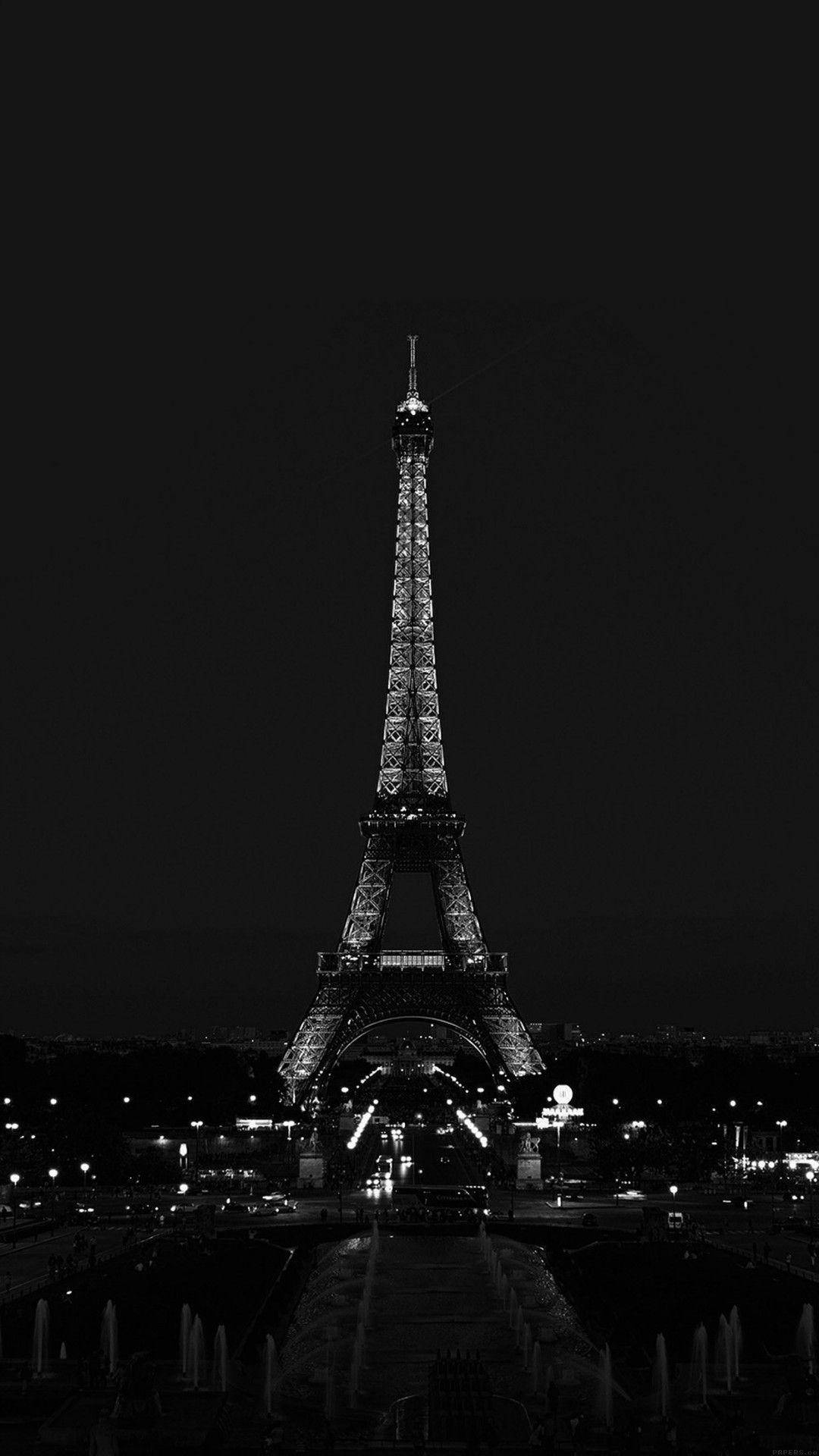 Eiffel Tower 桌布 壁紙 — 艾菲爾鐵塔在漆黑的夜空中亮起，呈現鮮明的黑白對比。