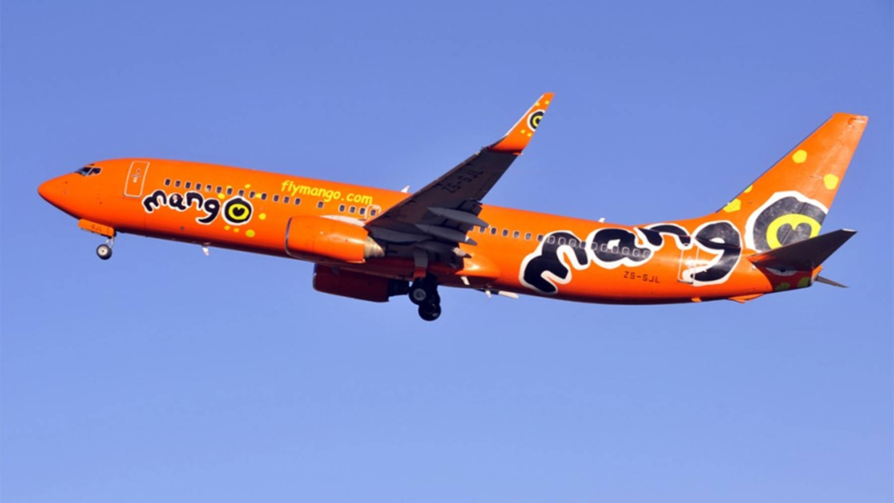 橙色Mango Airlines噴射機喺晴朗藍天中飛行