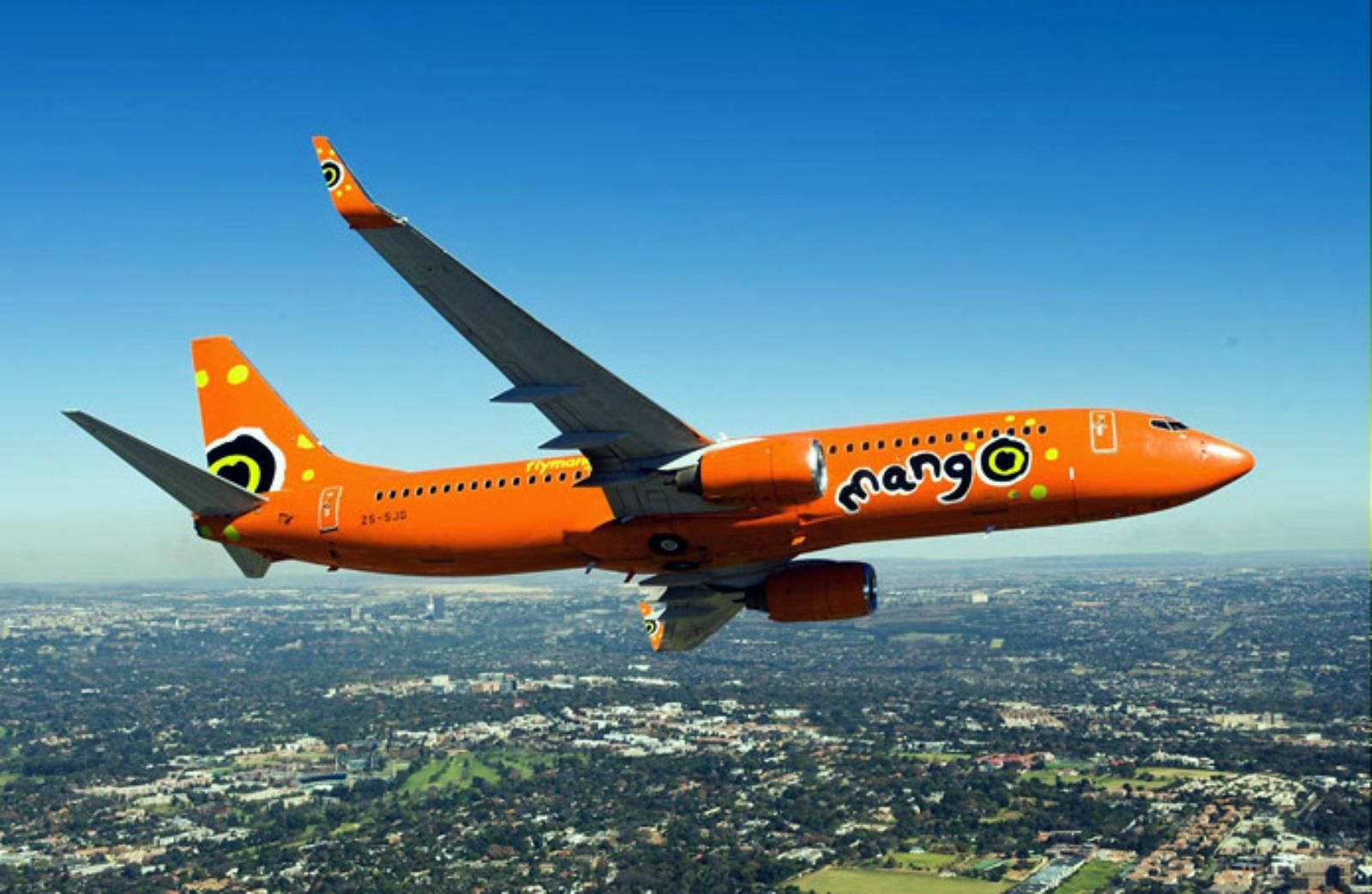 橙色Mango Airlines飛機在白天飛越城市上空。