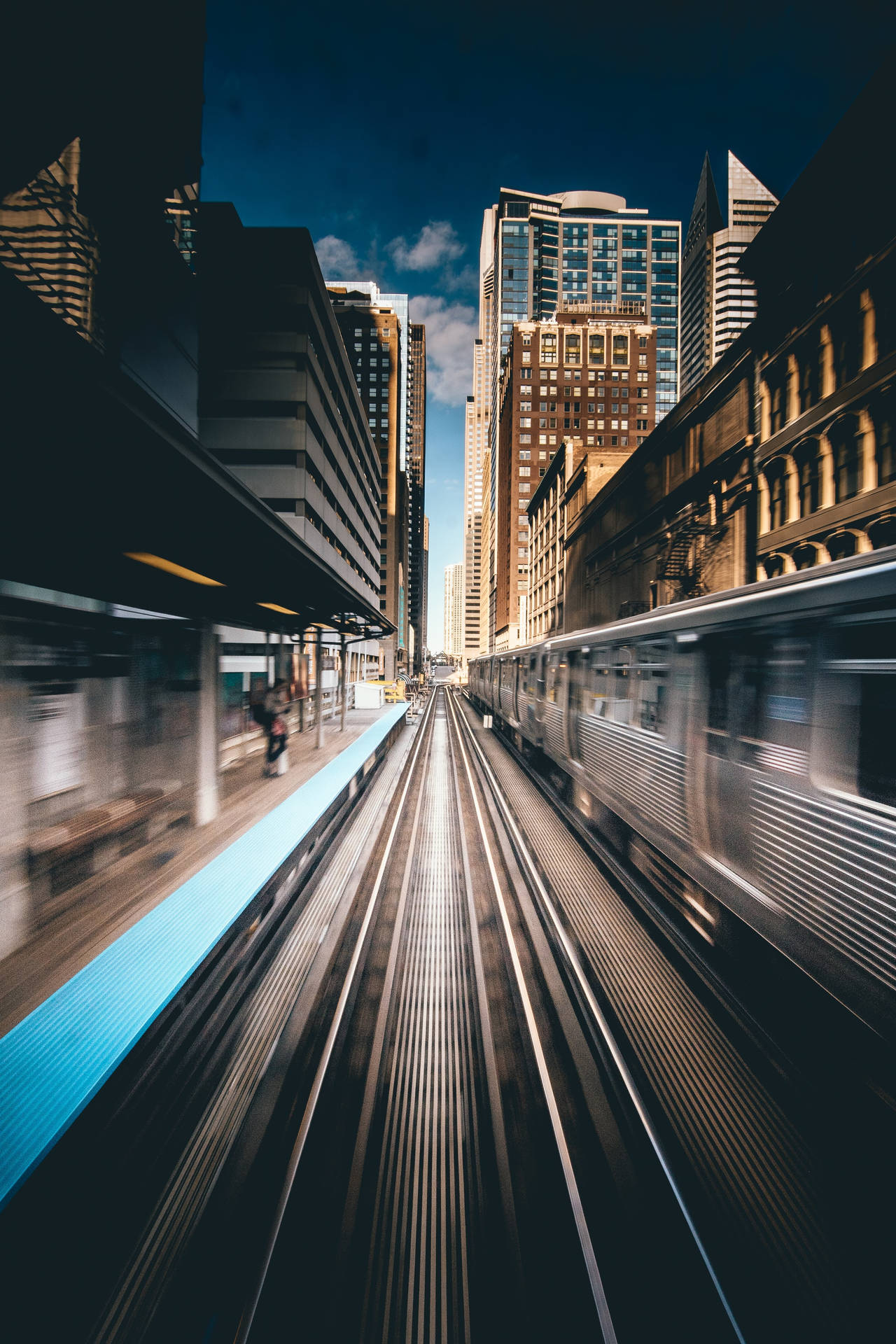 高架火車在繁華的城市中掠過，周圍是高聳的建築物。