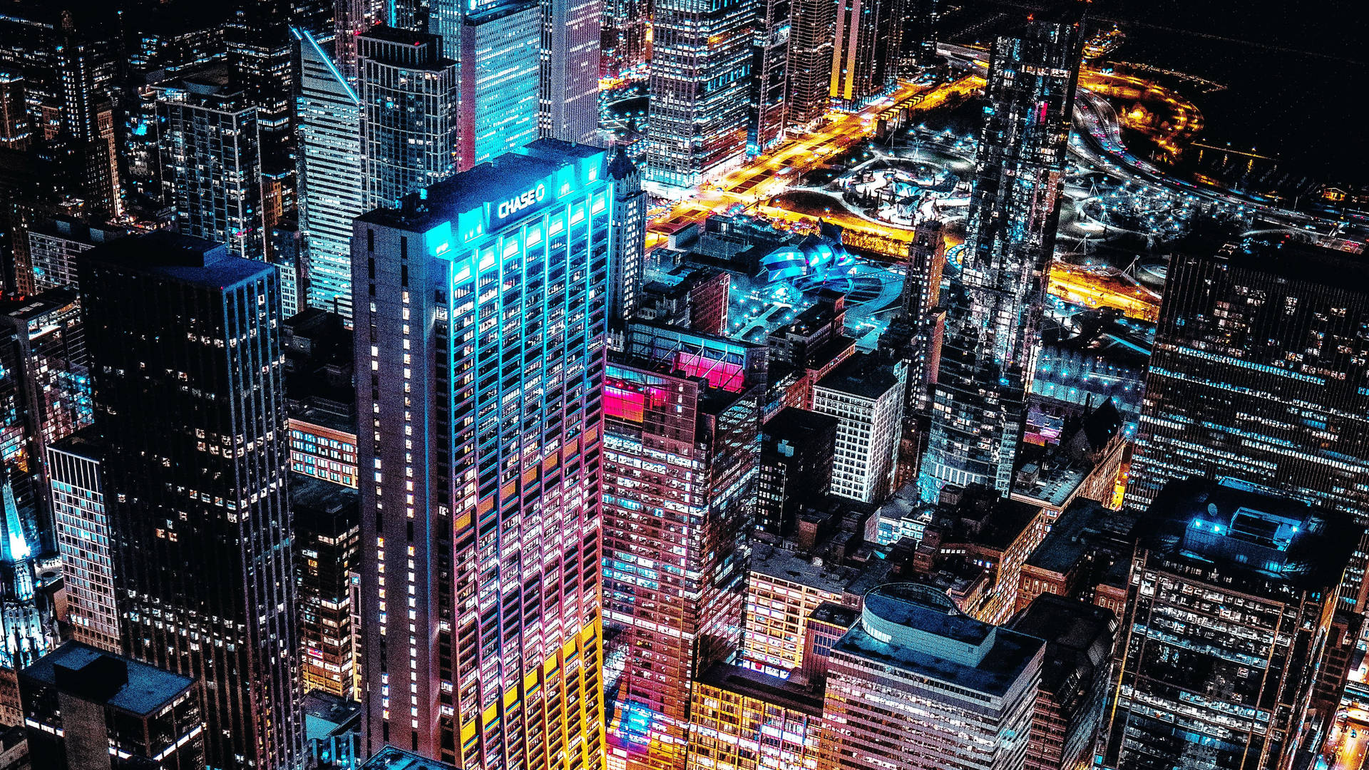 夜晚燈火通明的城市鳥瞰圖，高聳的摩天大樓和發光的街道。
