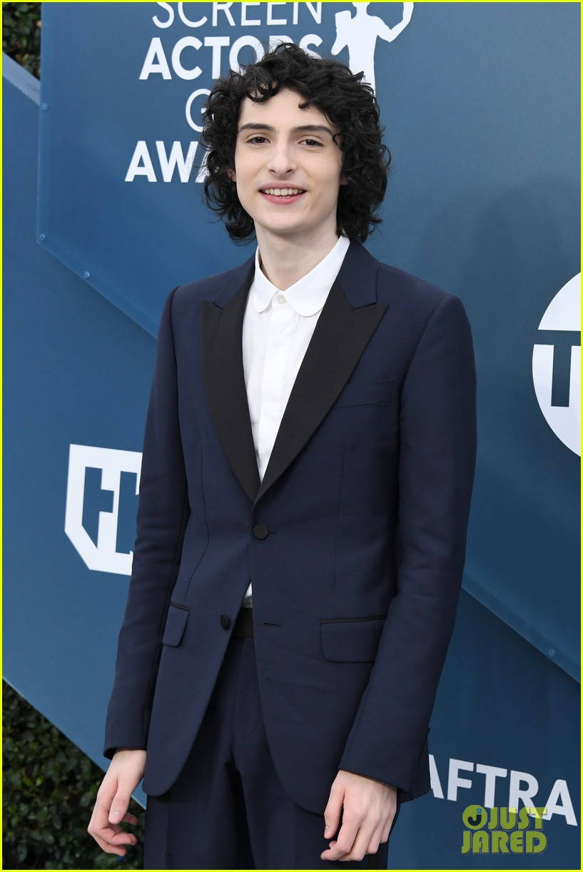 身穿海軍藍色燕尾服的年輕演員在Screen Actors Guild Awards上微笑。