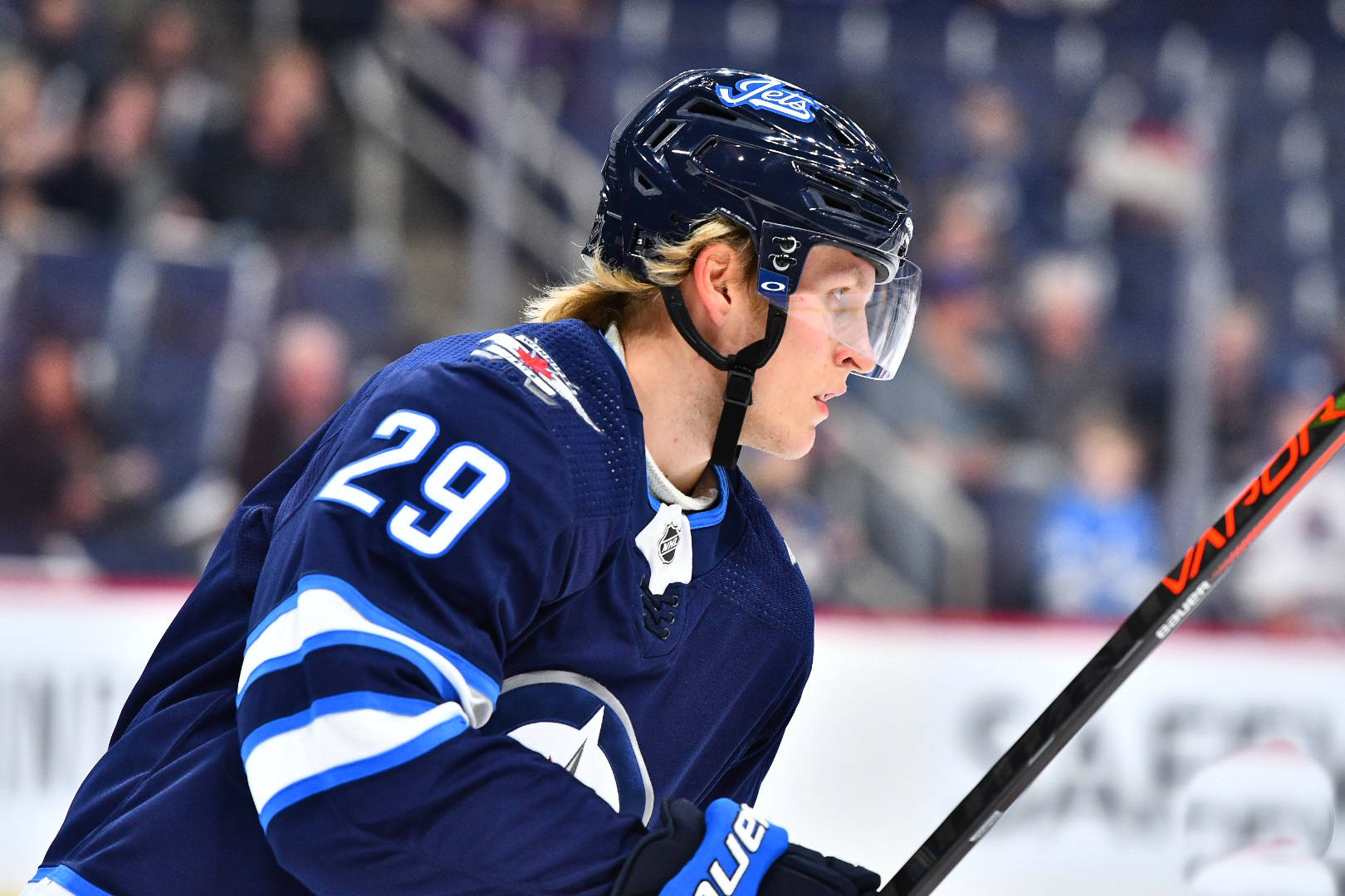 芬蘭職業鋒線帕特里克·萊恩 壁紙 — 一位專注的冰球運動員身穿藍色球衣，背號29，在比賽中於冰上俯身持桿。