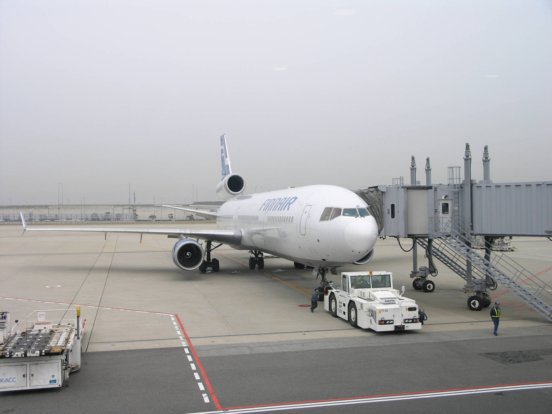 芬蘭航空飛機停泊在機場閘口，有登機橋和地勤人員。