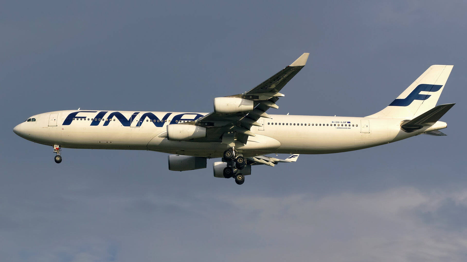 芬蘭航空飛機放下起落架，在多雲的天空背景下下降。