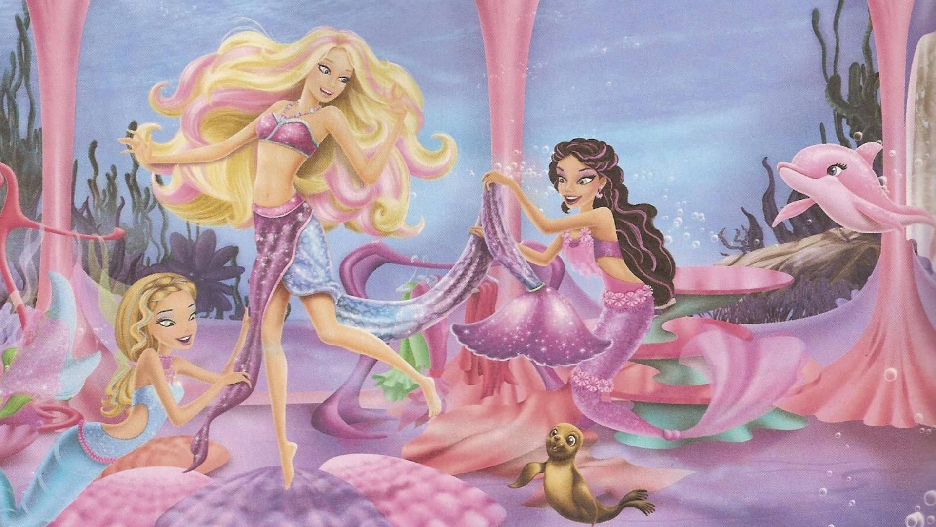 芭比美人魚展現雙腿 壁紙 — 三位長髮飄逸、擁有粉紫色尾巴的美人魚，與海豚和海豹在水下歡快地跳舞。
