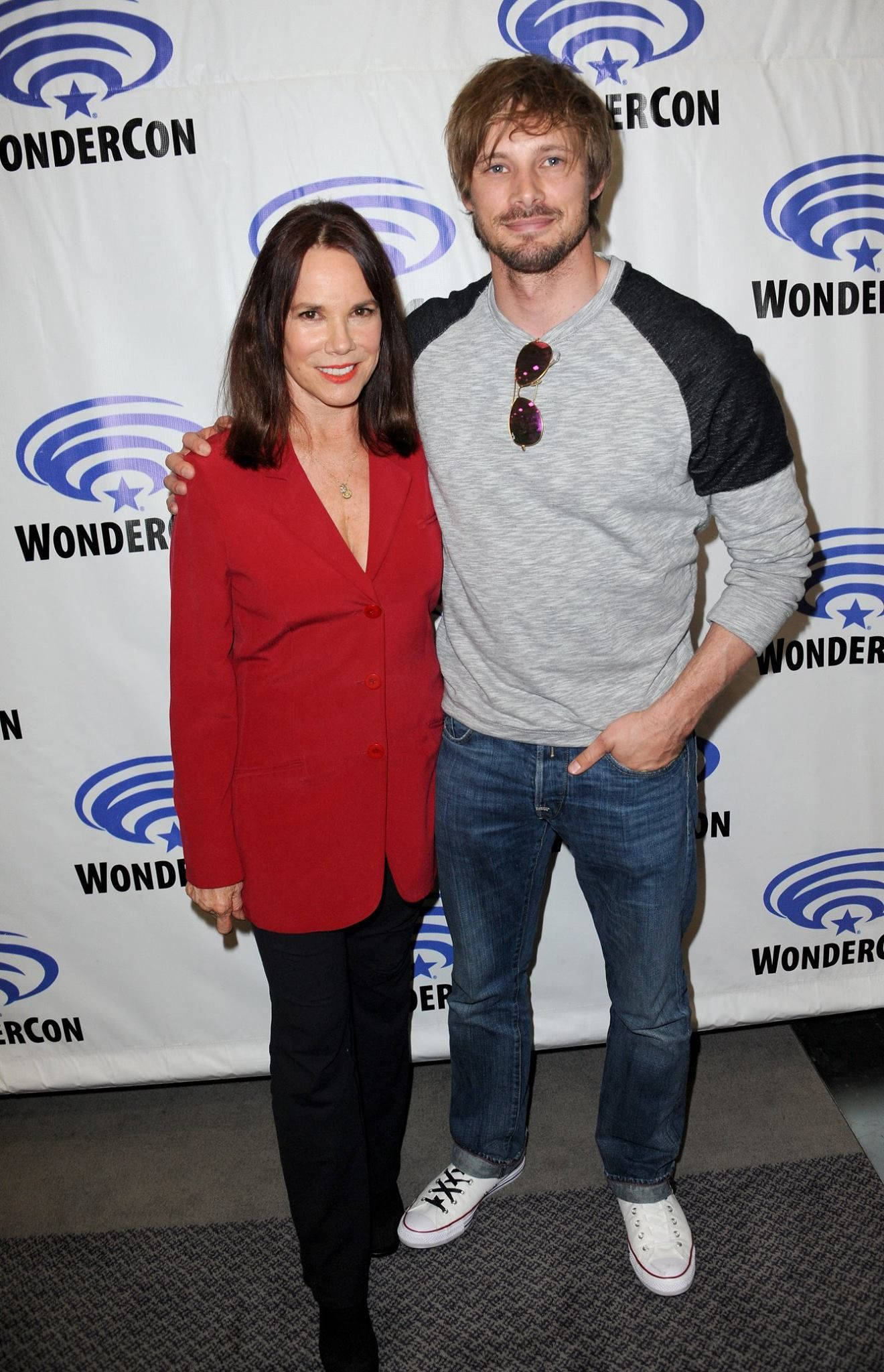 芭芭拉·赫西與布拉德利·詹姆斯出席WonderCon 壁紙 — 兩個微笑的人喺WonderCon活動中一齊擺甫士，背景係有品牌標誌嘅佈景。
