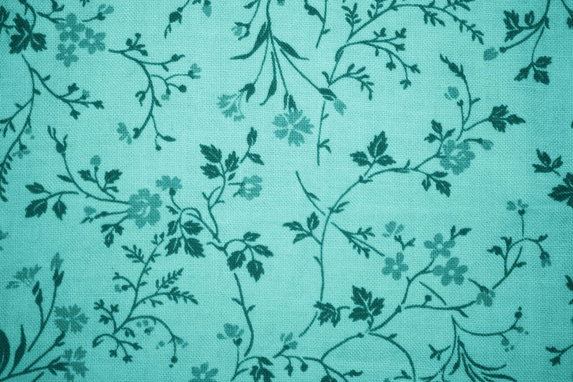 帶有深綠色花藤同花朵圖案嘅青綠色布料。