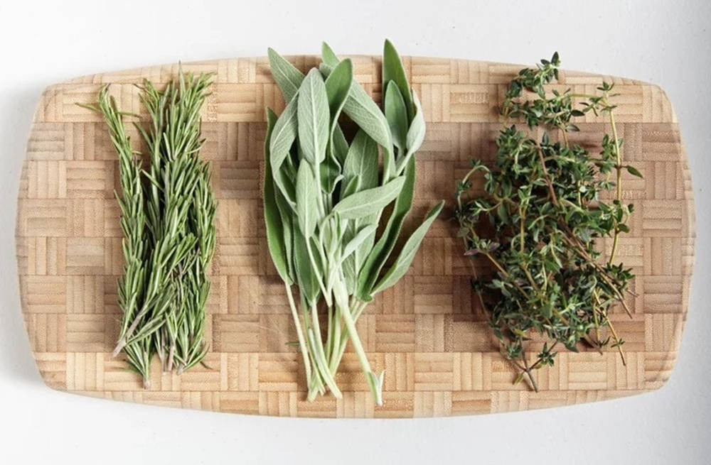 花園中的新鮮 sage 草本植物 壁紙 — 三種新鮮香草迷迭香鼠尾草和百里香整齊地排列在淺色木砧板上。