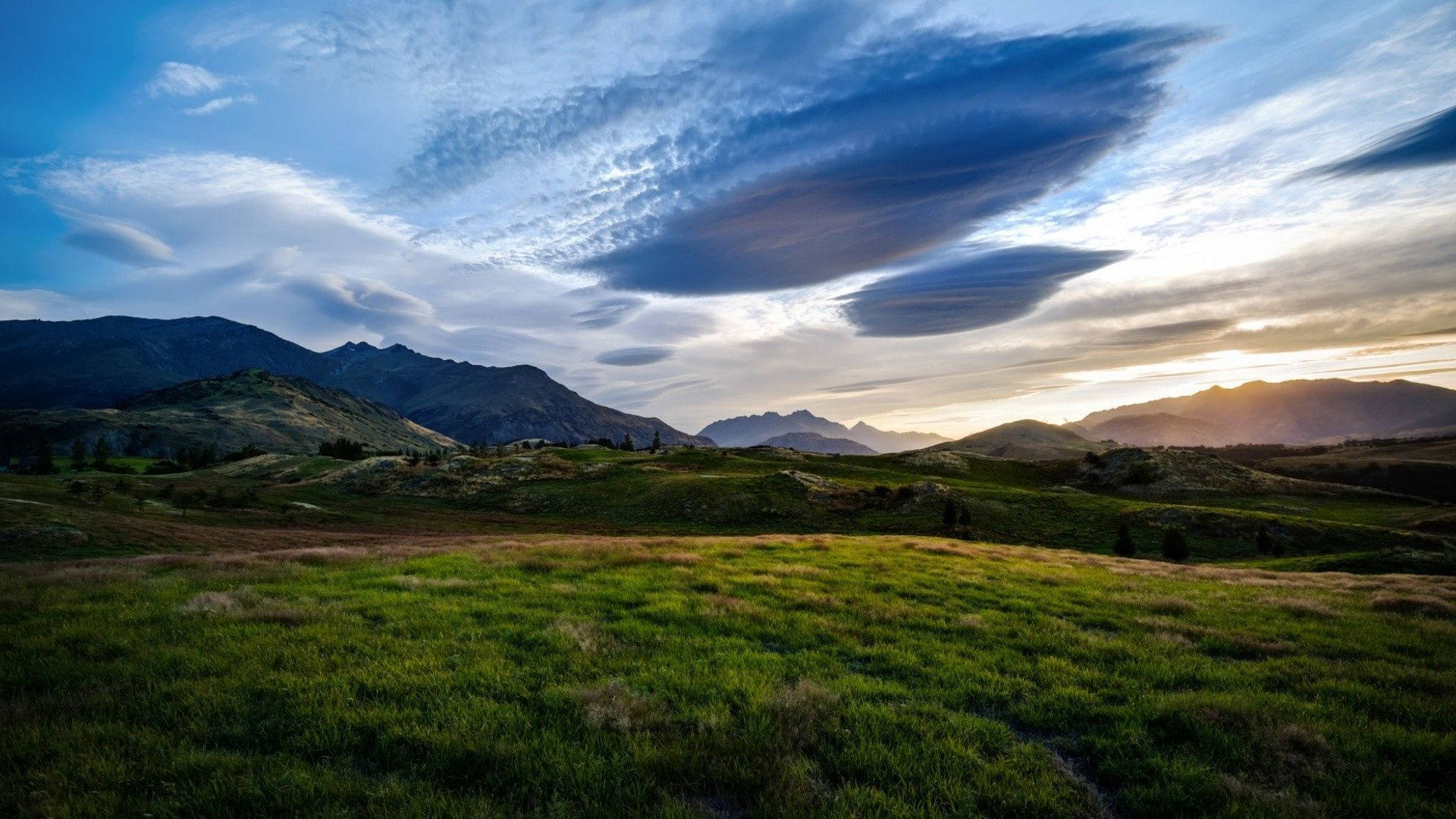 夕陽下山區草地與戲劇性的透鏡狀雲。