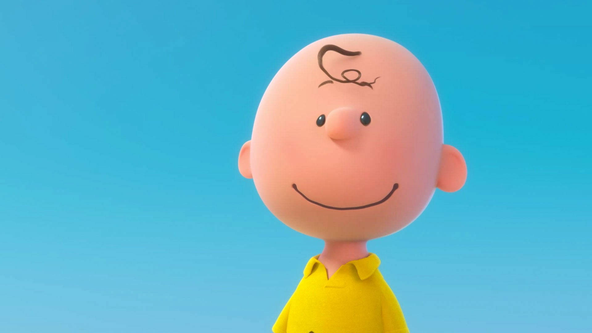 Charlie Brown 身穿黃色襯衫在藍色背景前微笑