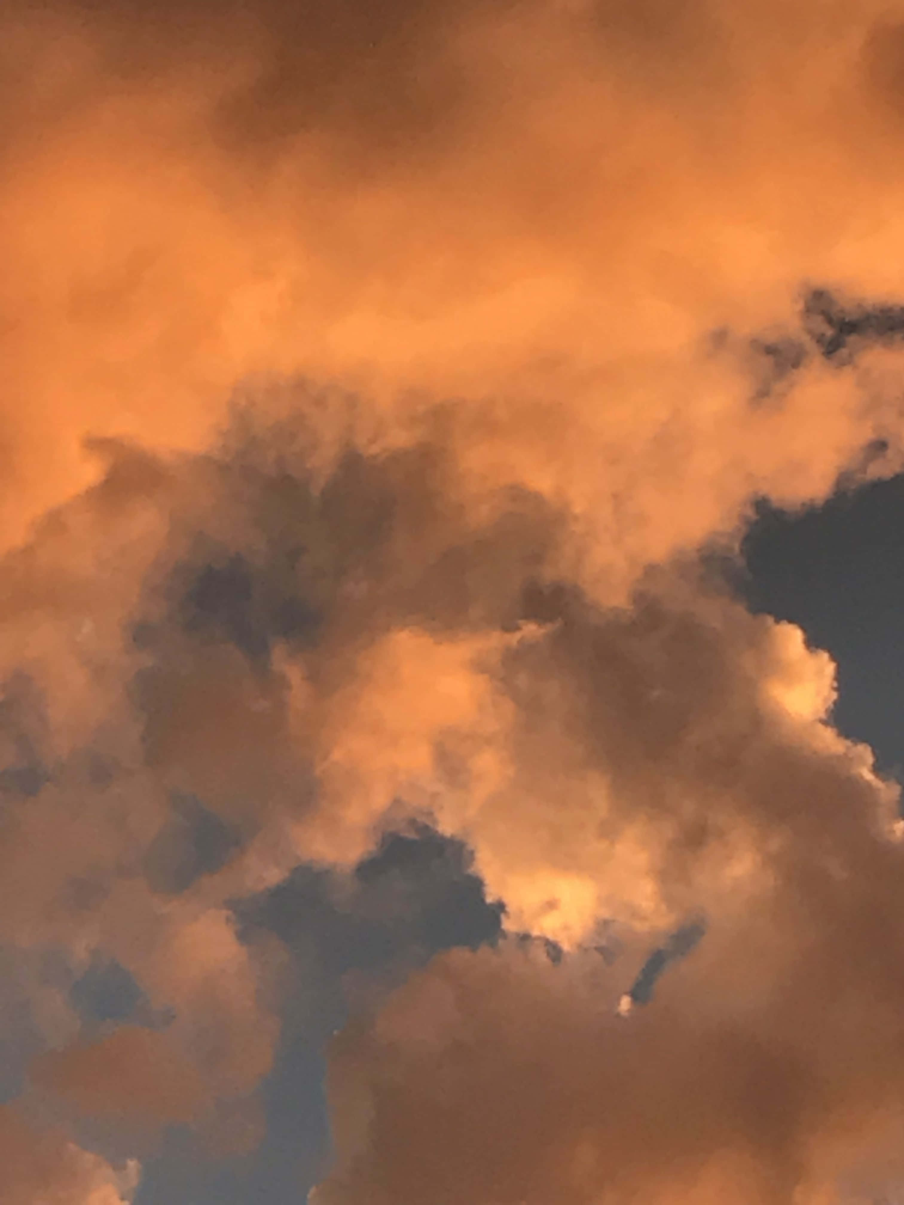 花點時間欣賞雲朵的美學 壁紙 — 廣闊的雲層在暮色天空中散發出火橙色和深藍色的陰影。