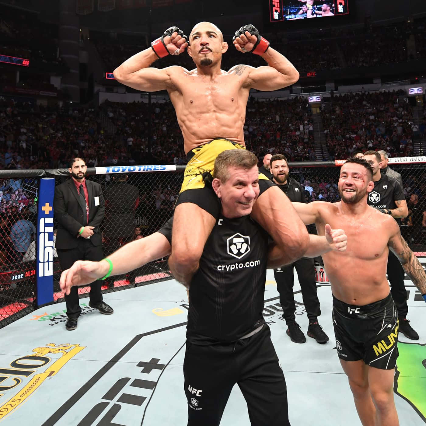 UFC拳手在八角籠內獲勝後在教練肩上慶祝。