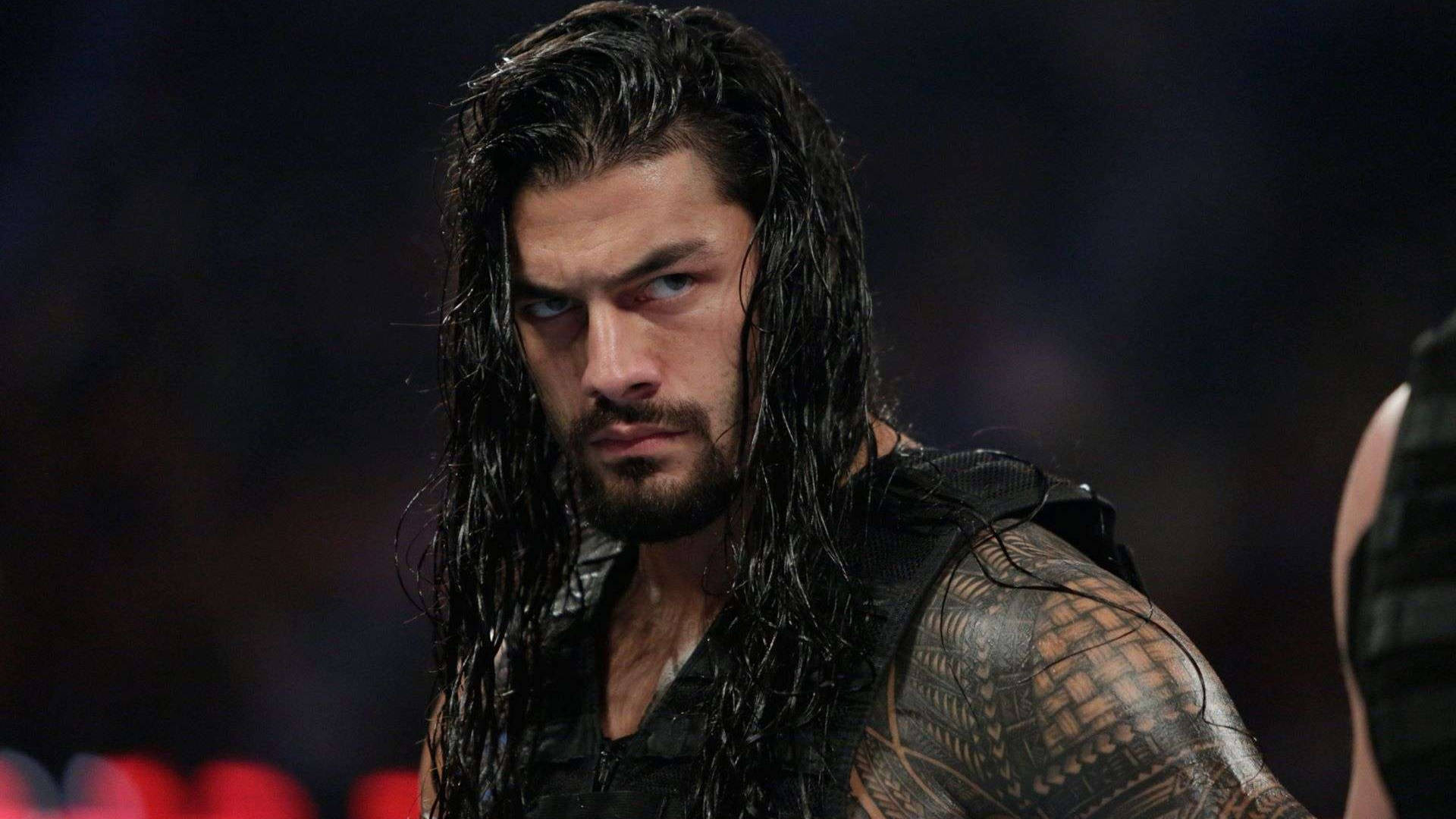 摔角手 Roman Reigns 濕頭髮和紋身在黑暗的競技場中。