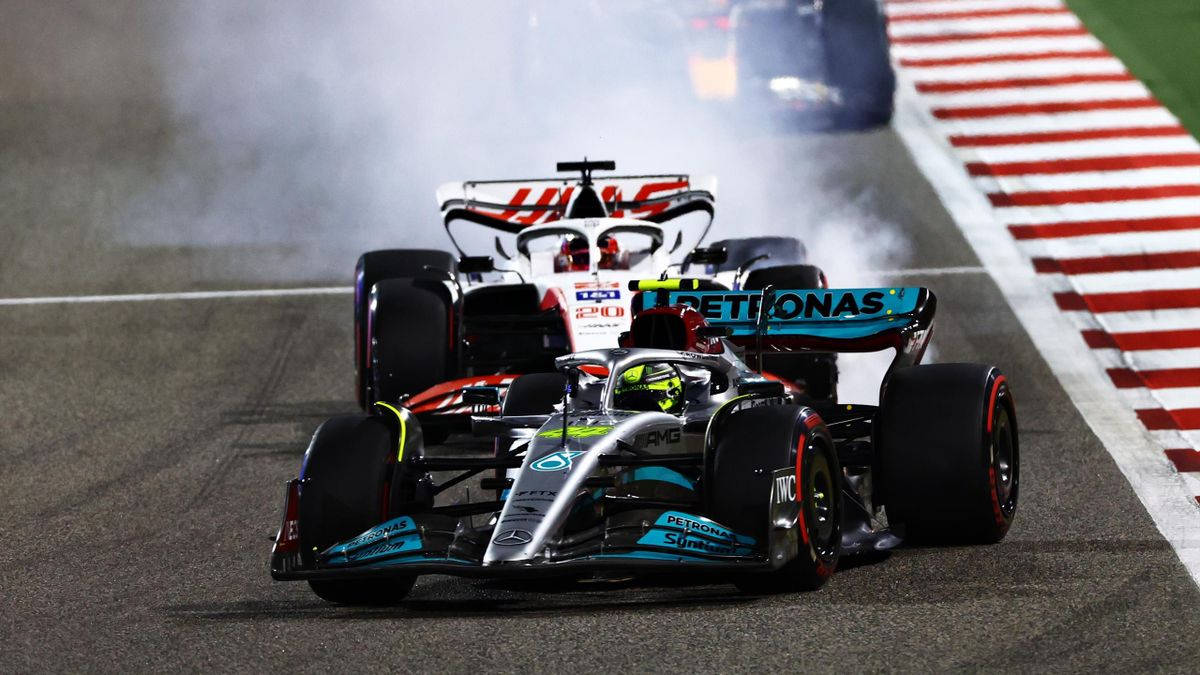 英國F1冠軍劉易斯·漢密爾頓展現駕駛本領 壁紙 — 兩輛一級方程式賽車在潮濕的賽道上激烈爭鬥，輪胎冒出滾滾濃煙。